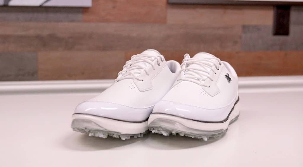 White leather golf shoes on table
