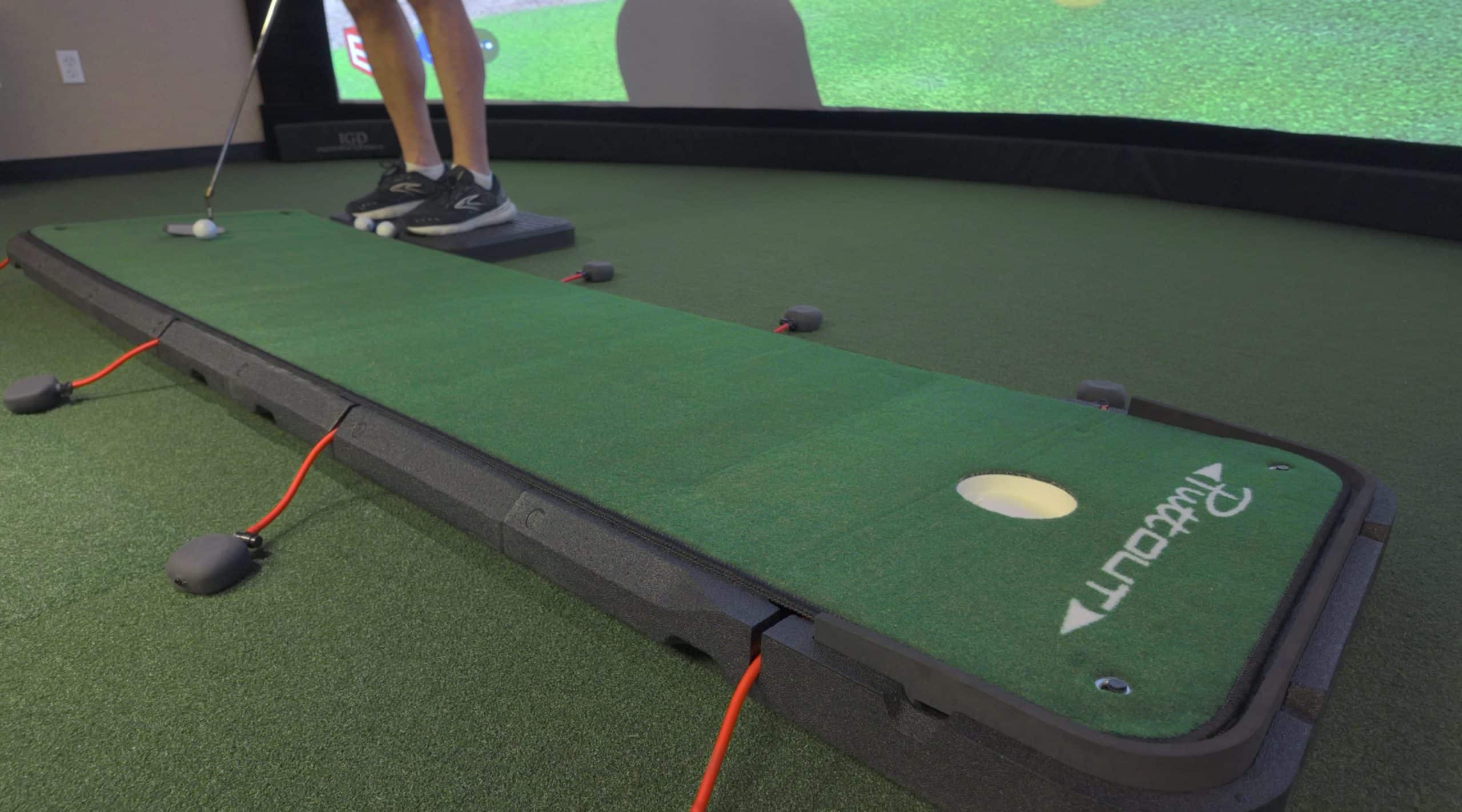 Person practicing putting on indoor golf simulator
