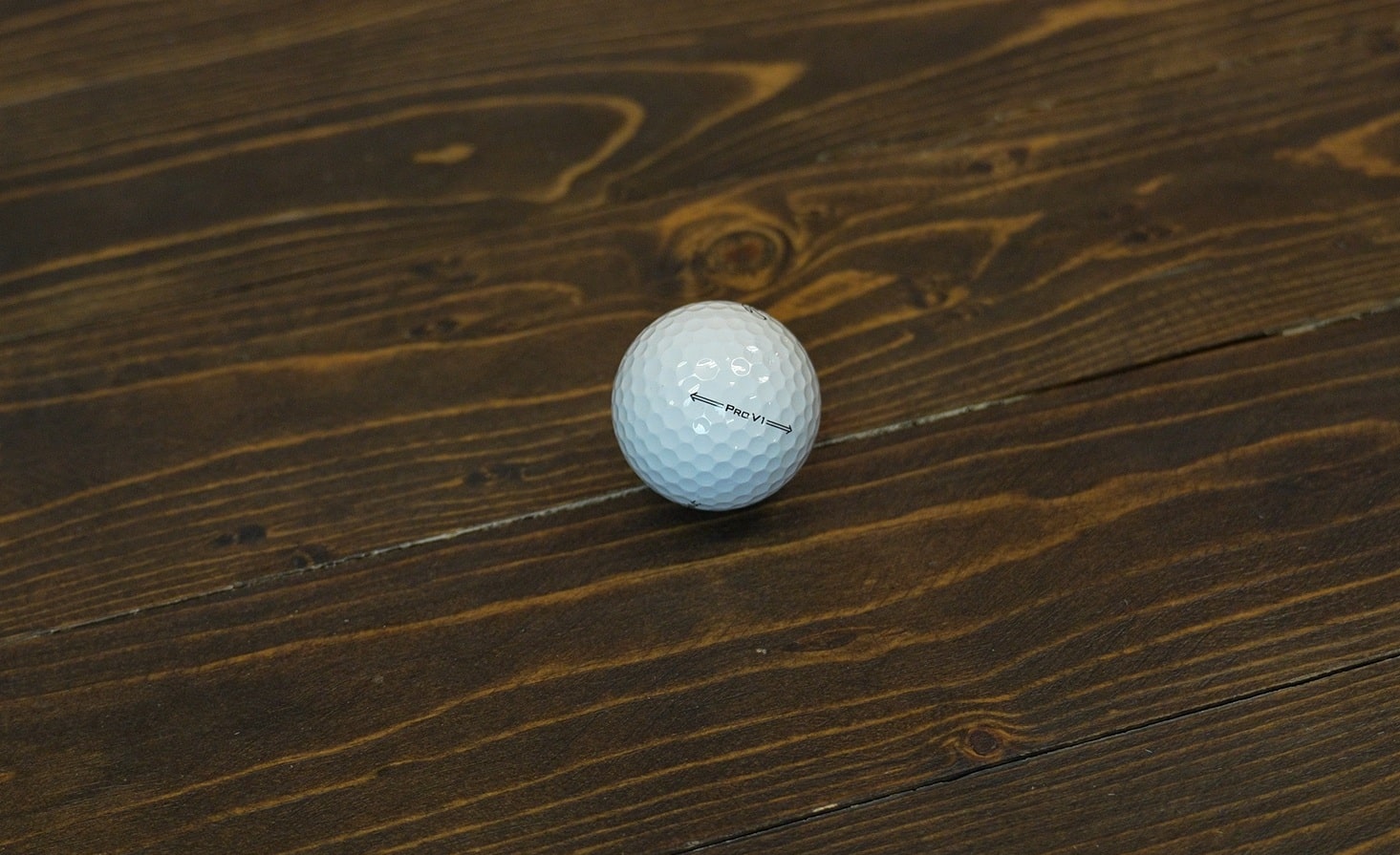 White golf ball on wooden surface
