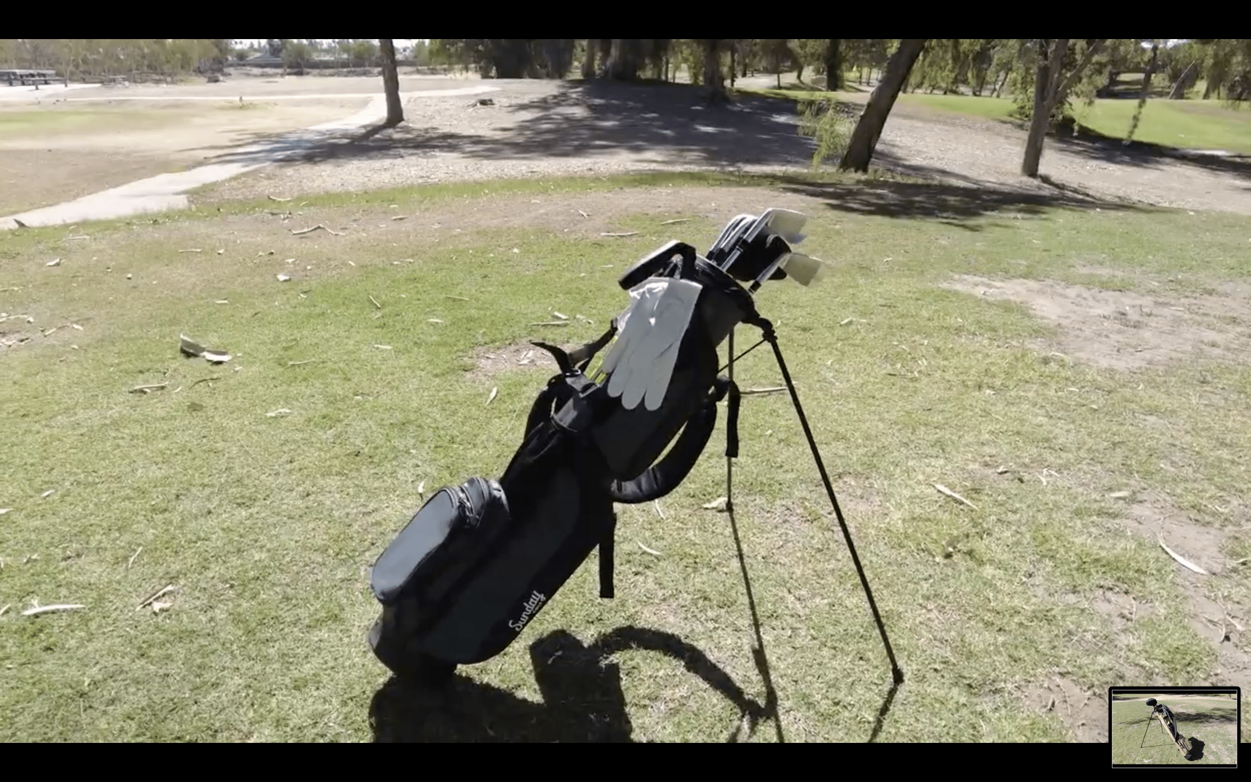 Golf bag with clubs on a grassy course