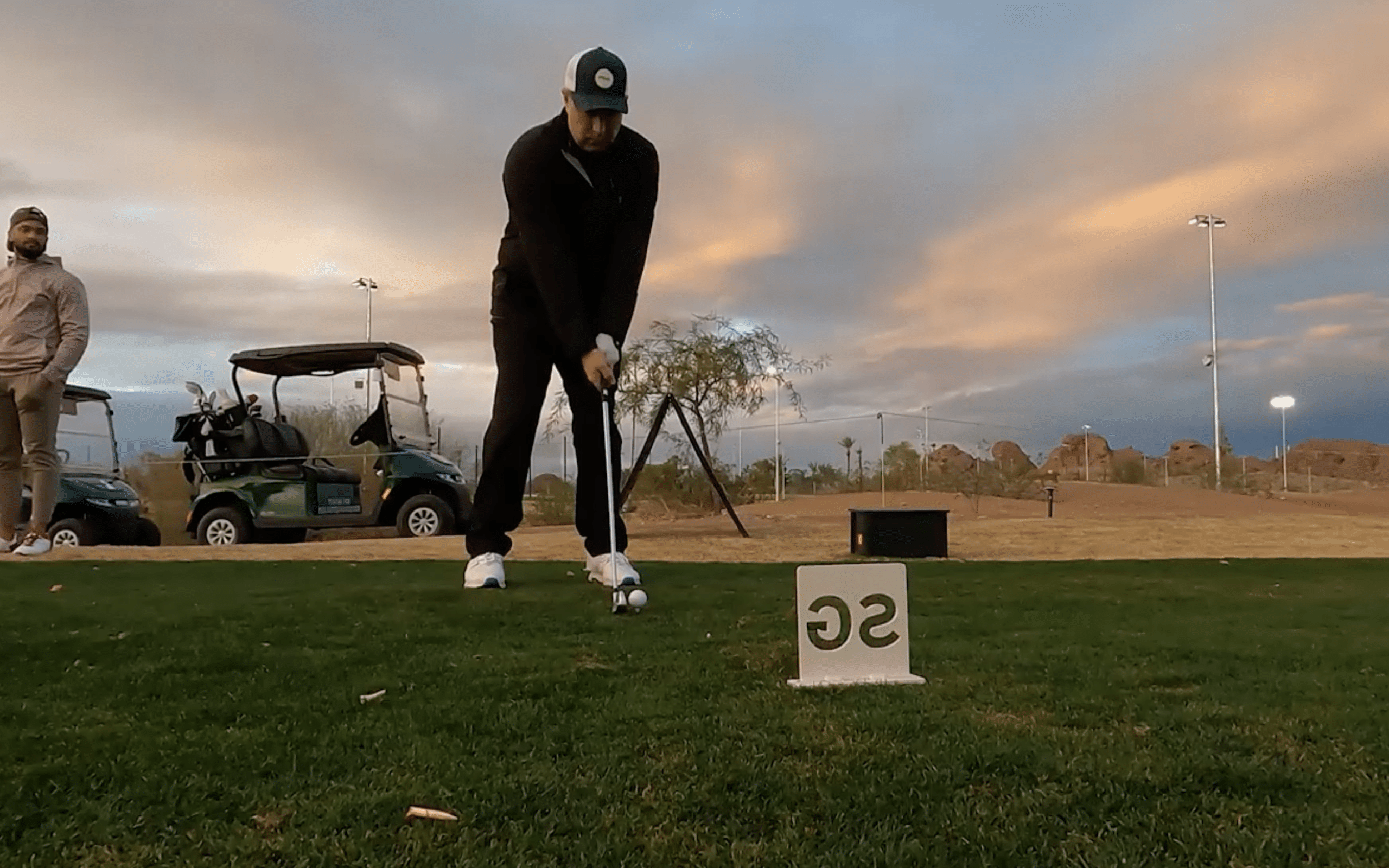 Golfer preparing to swing at sunset course