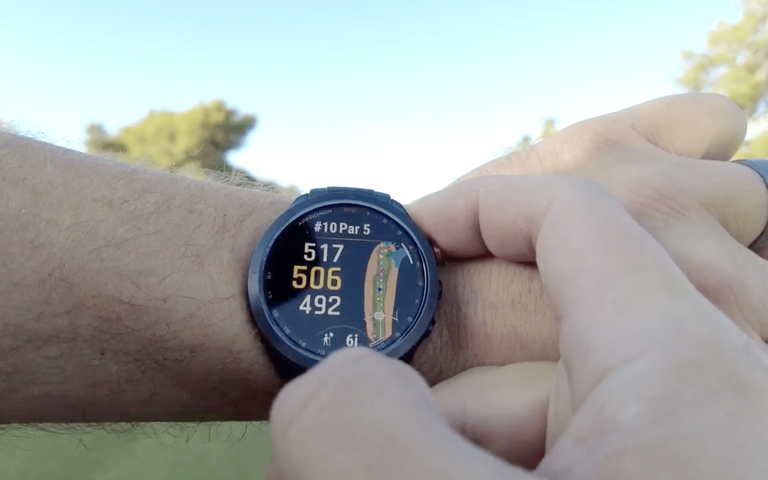 Person using golf GPS smartwatch outdoors