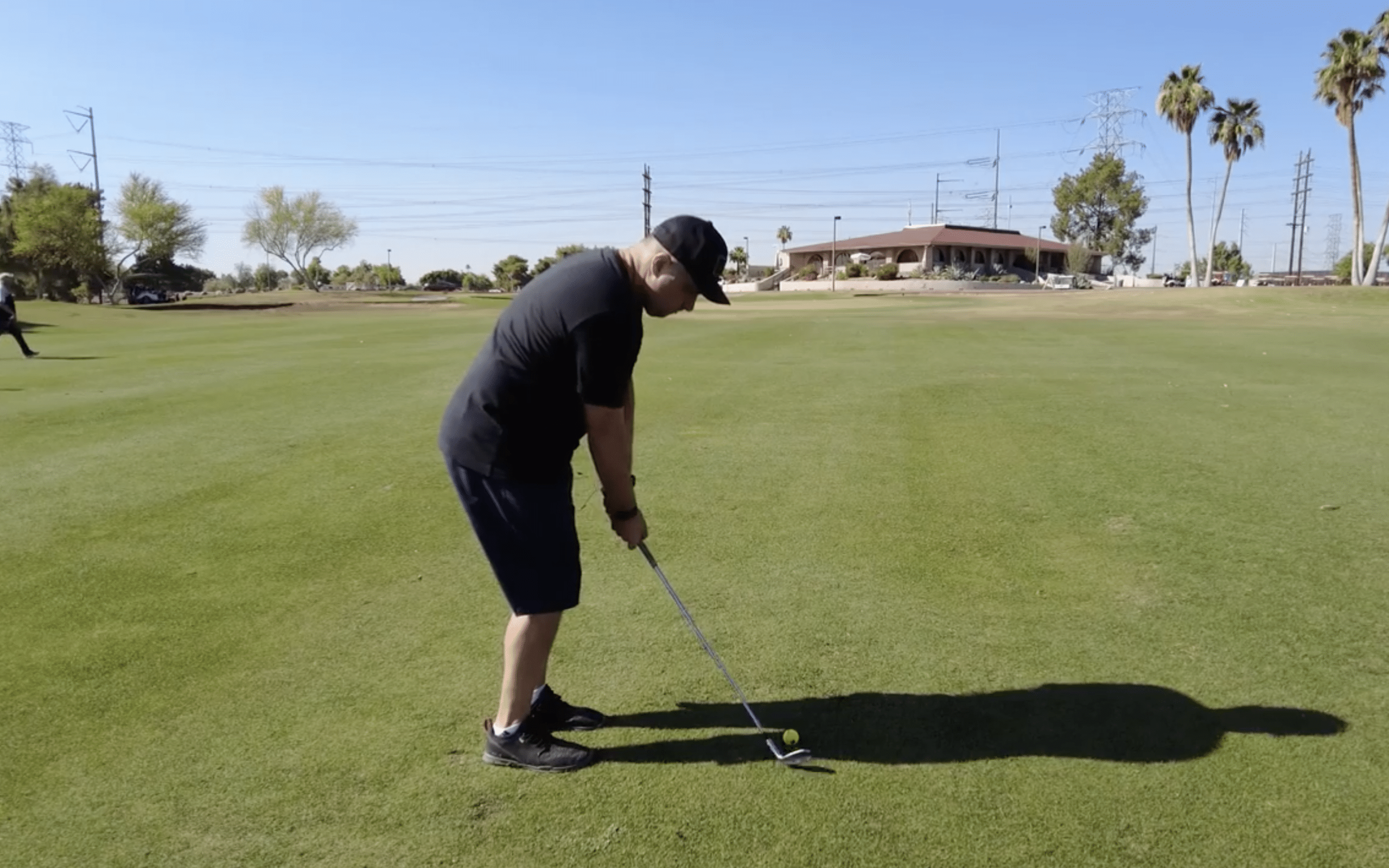 Golfer preparing to hit ball on sunny course