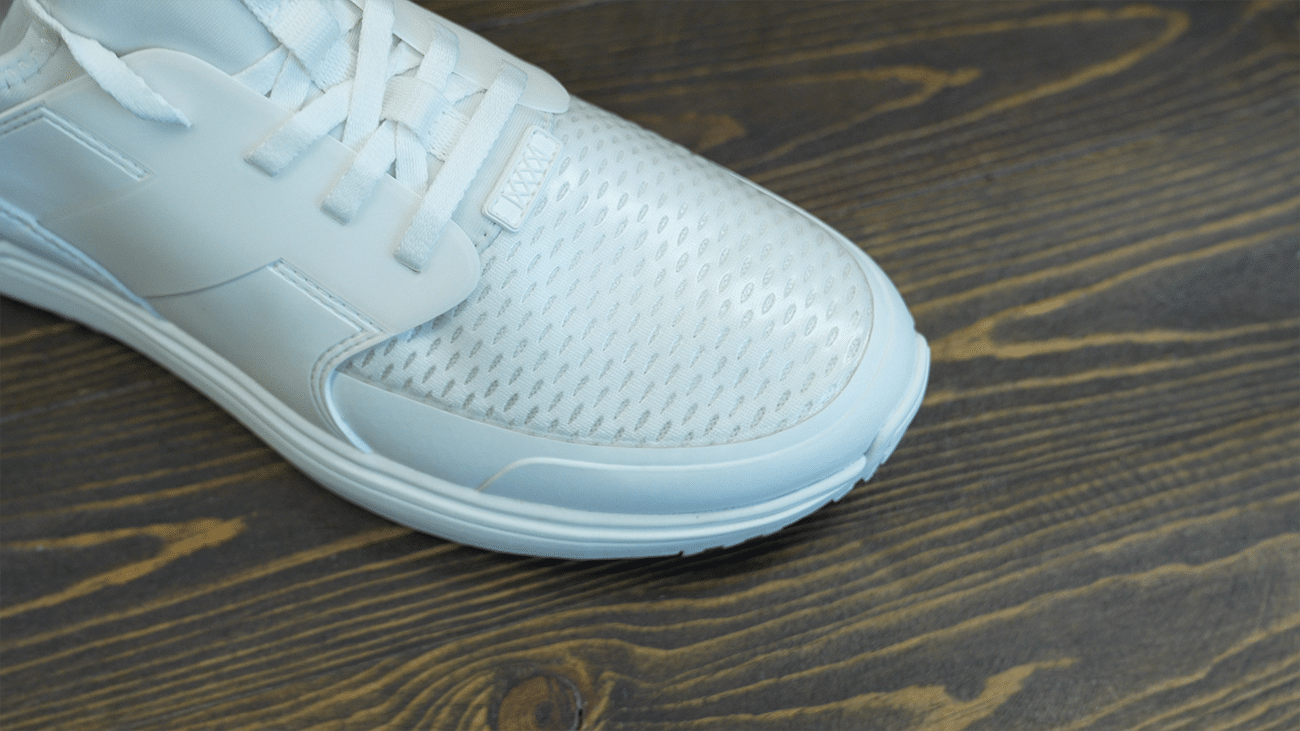 White athletic sneaker on wooden floor