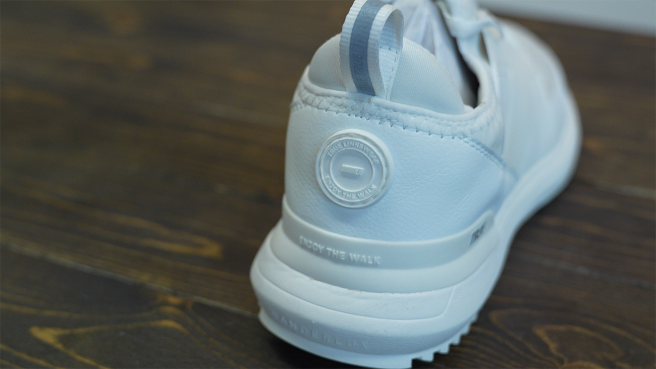 White sneaker on dark wooden surface