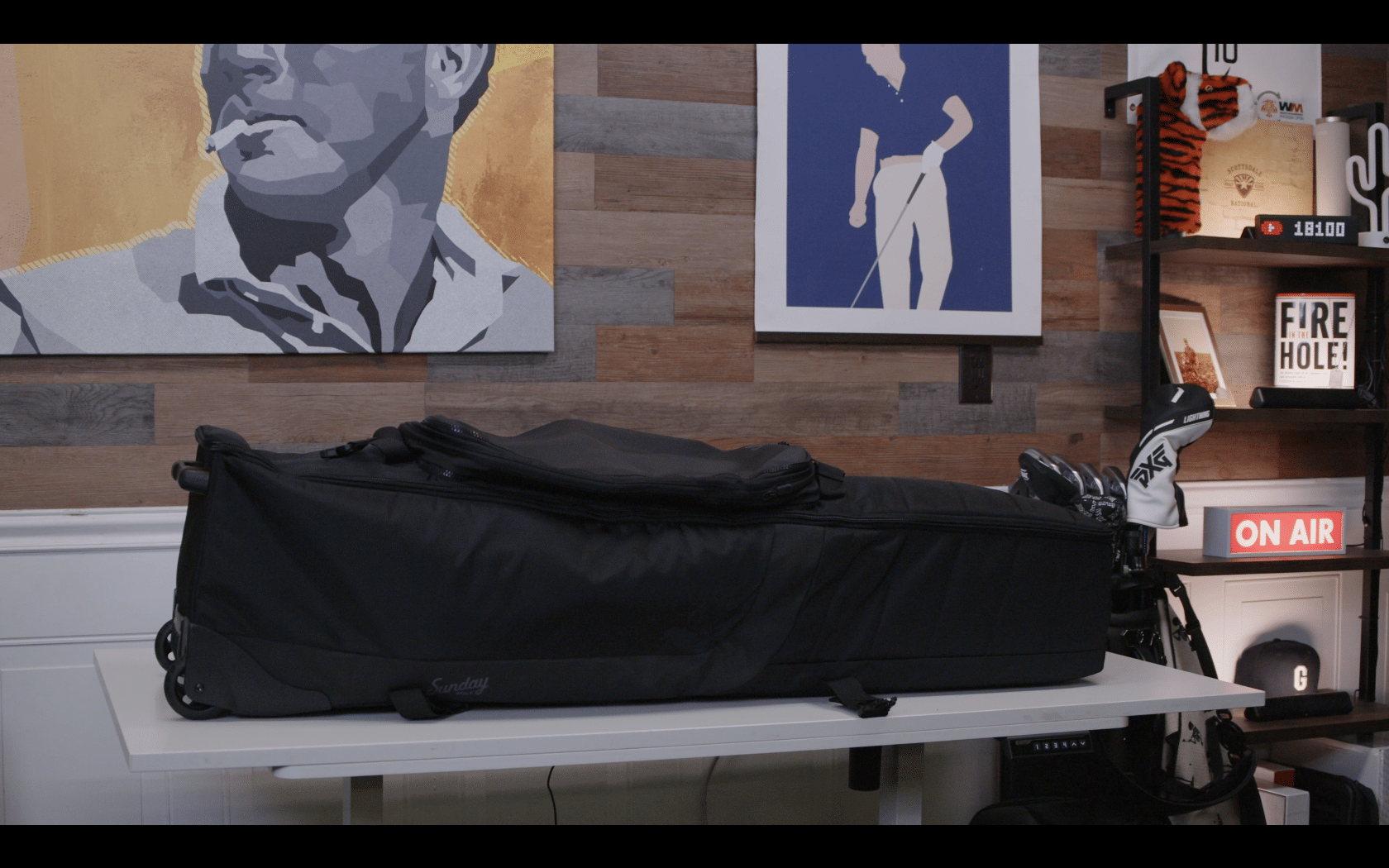 Black golf travel bag on white table