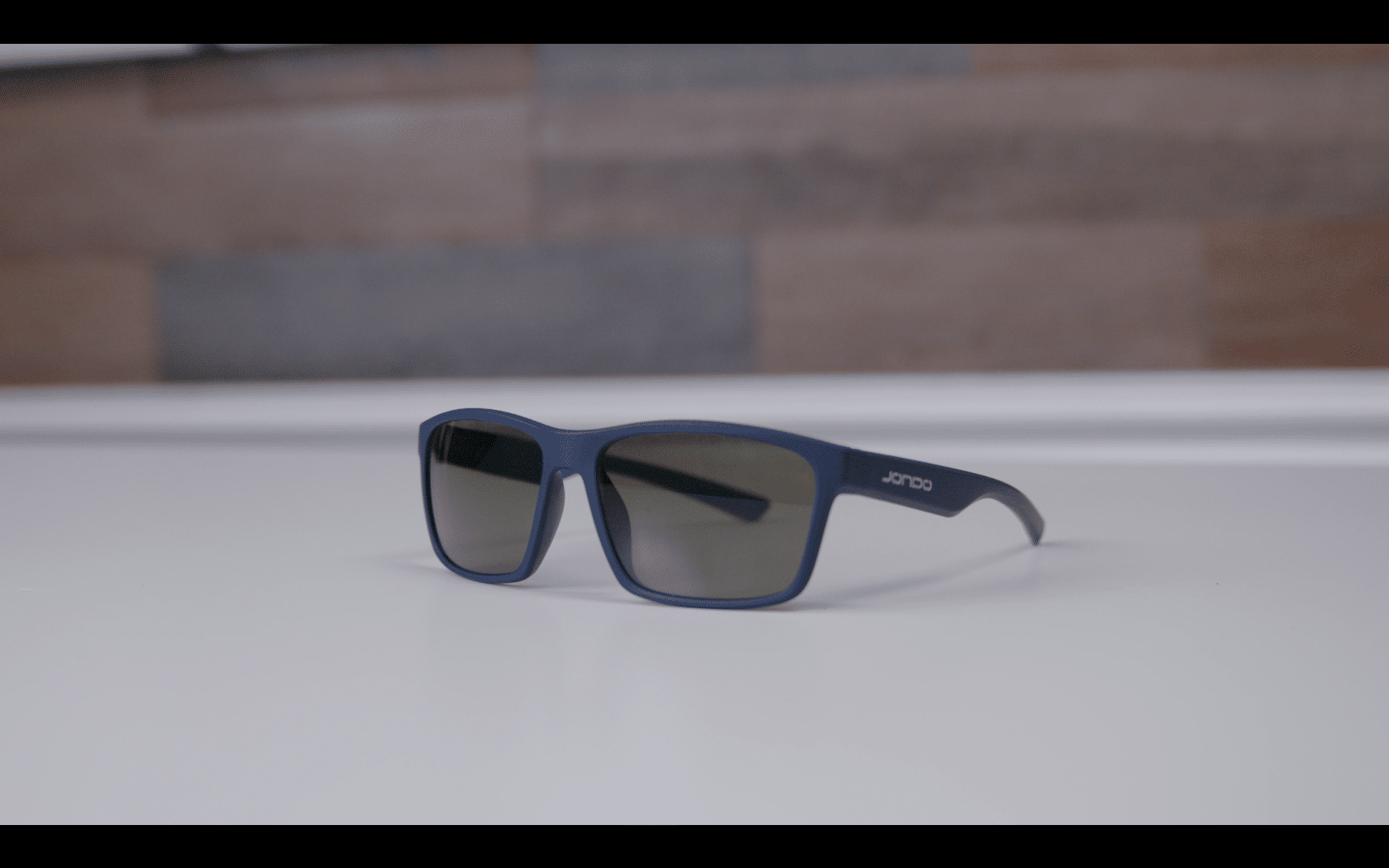 Blue sunglasses with dark lenses on table
