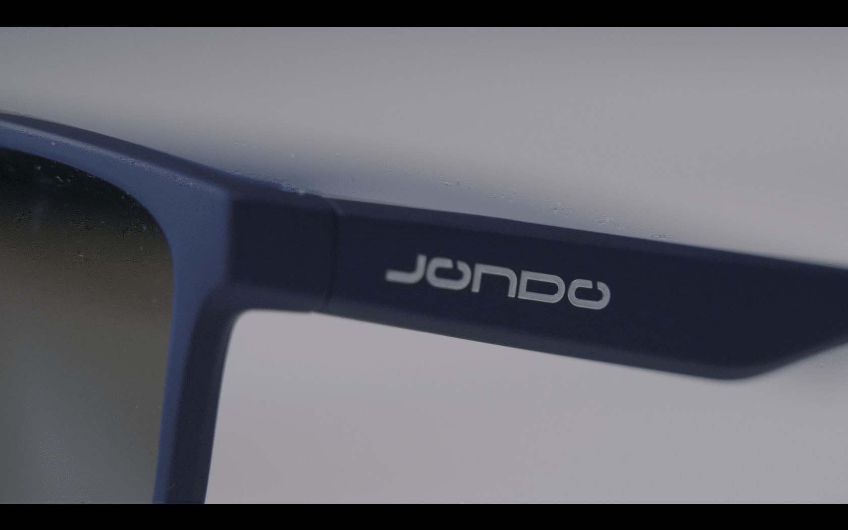 Close-up of blue sunglasses arm with logo