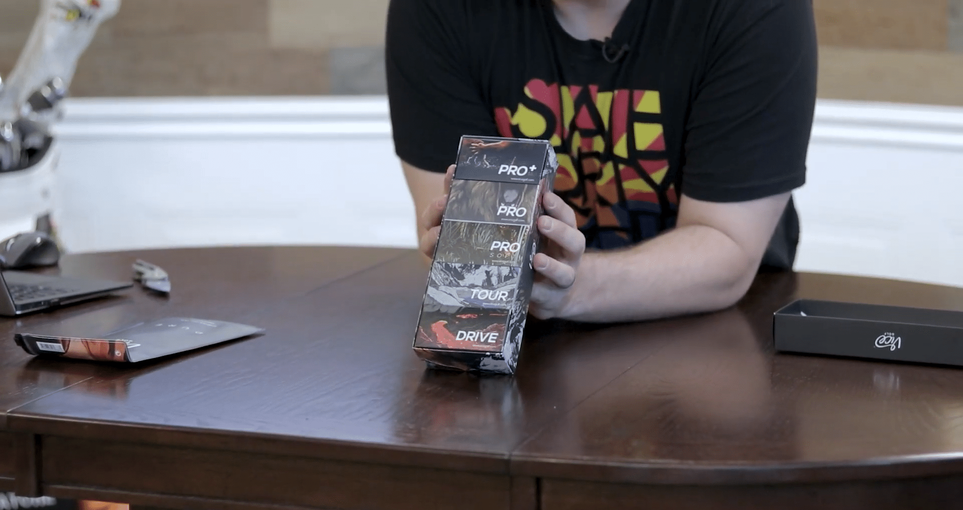 Person holding stacked golf ball boxes