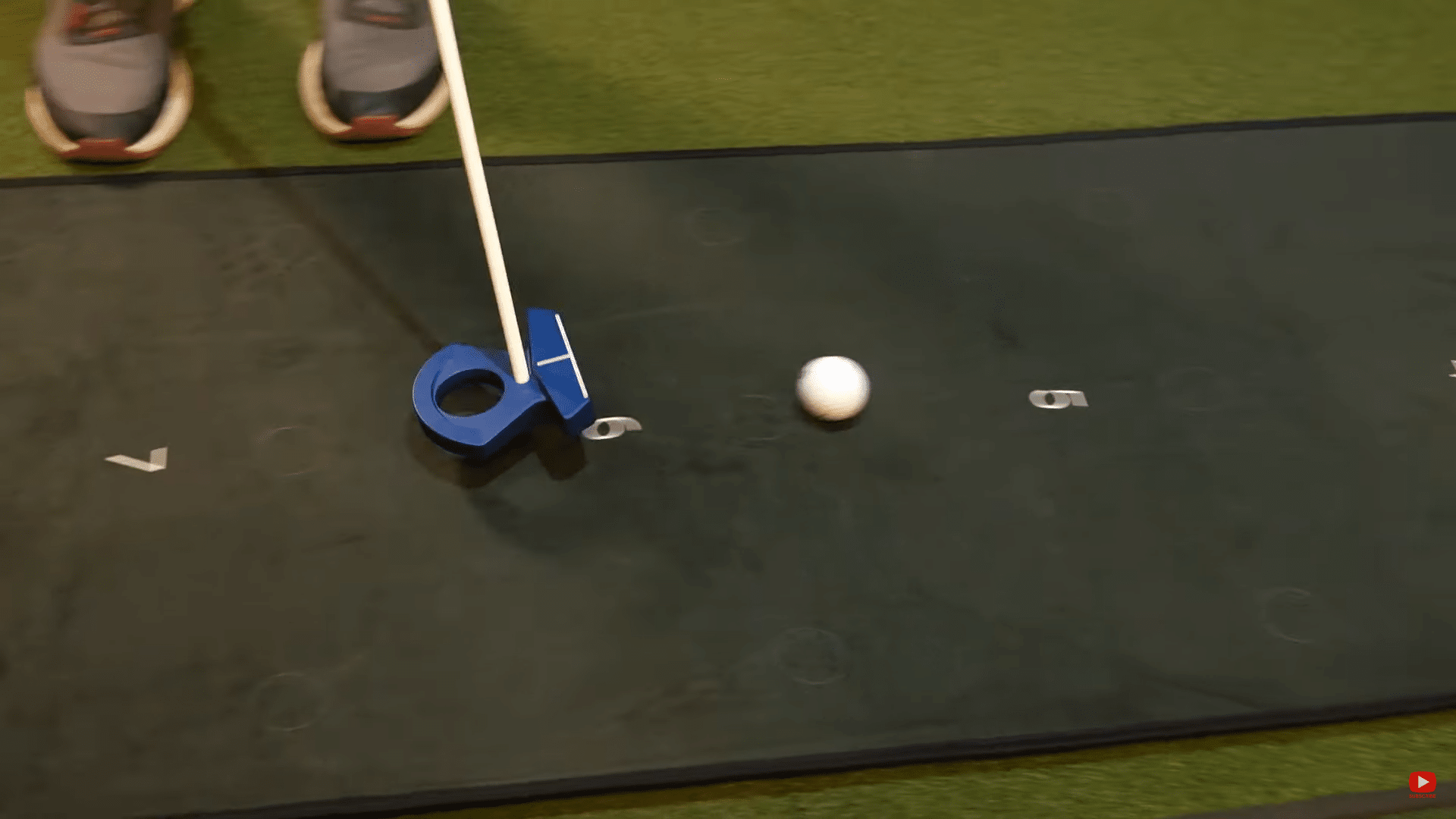 Person practicing putting on indoor golf mat