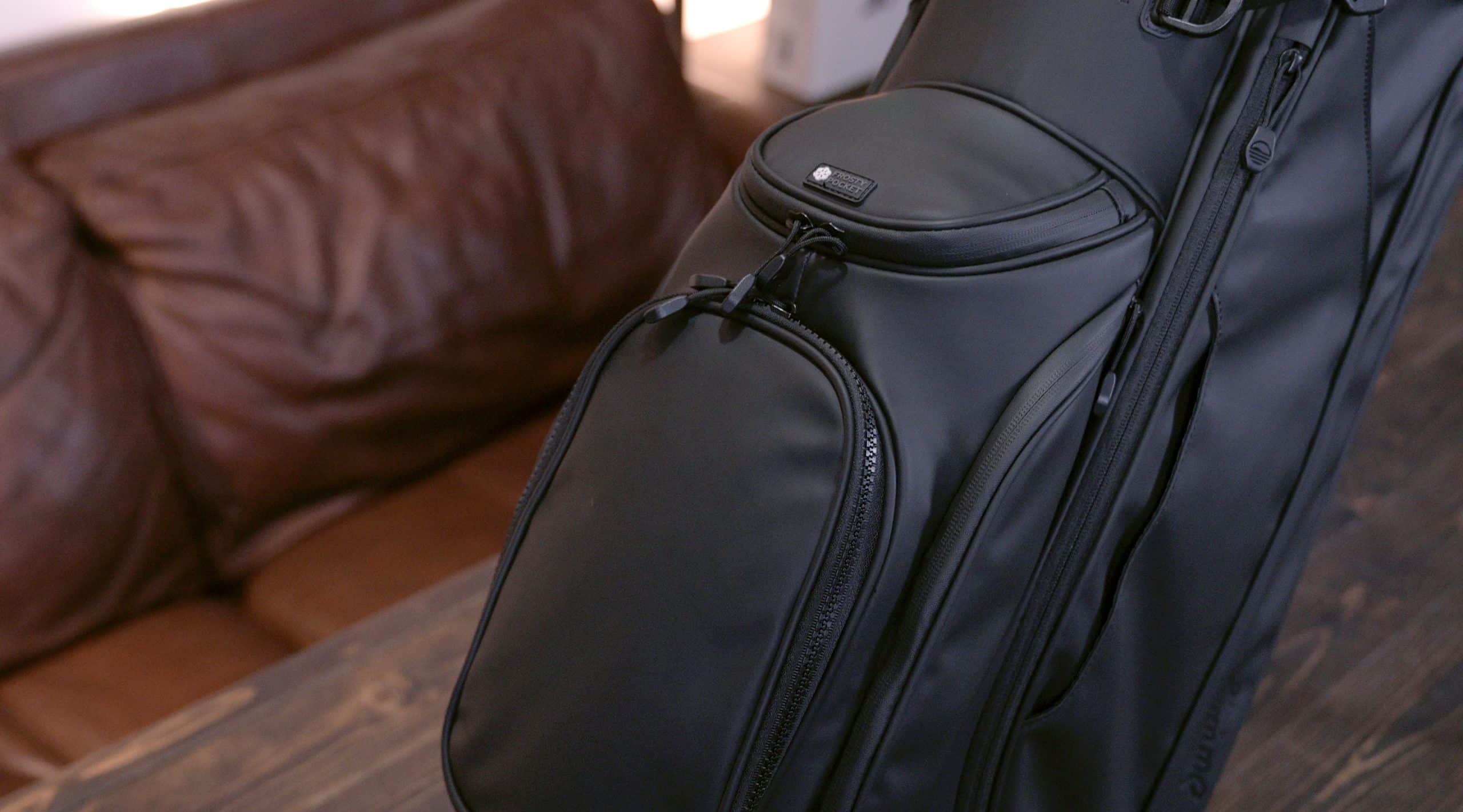 Black golf travel bag on wooden table
