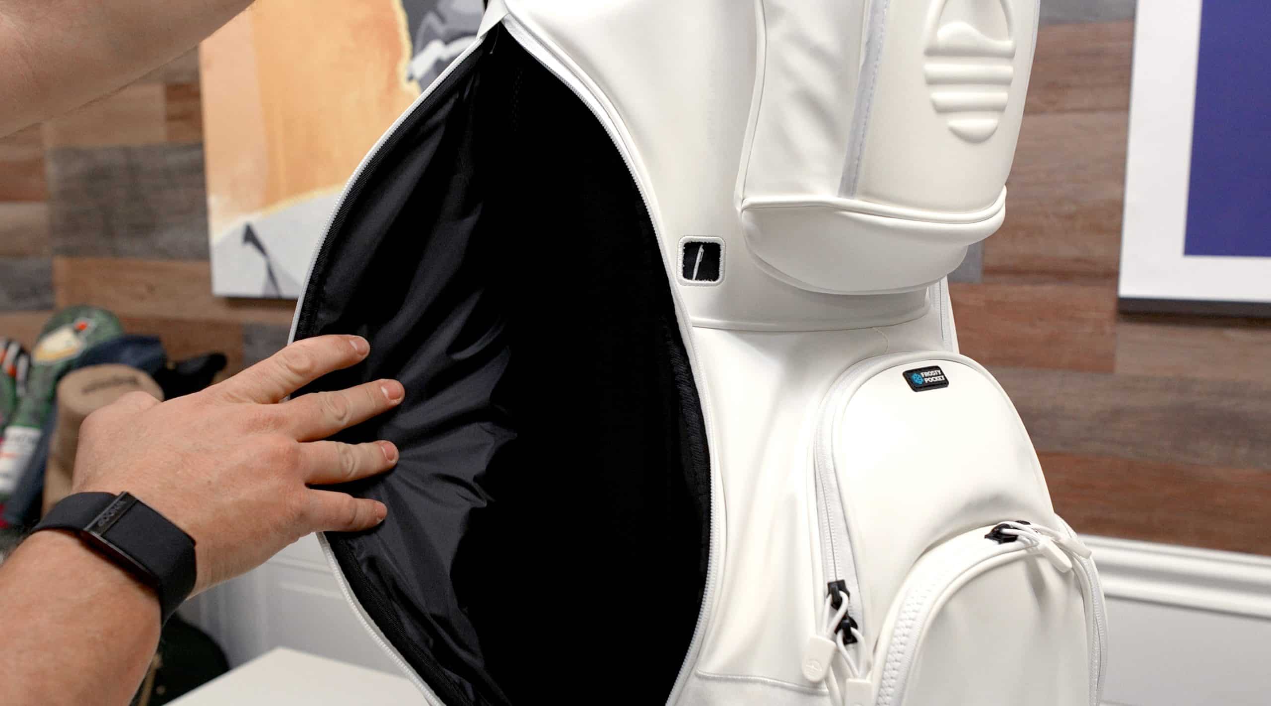 Person opening white golf bag pocket