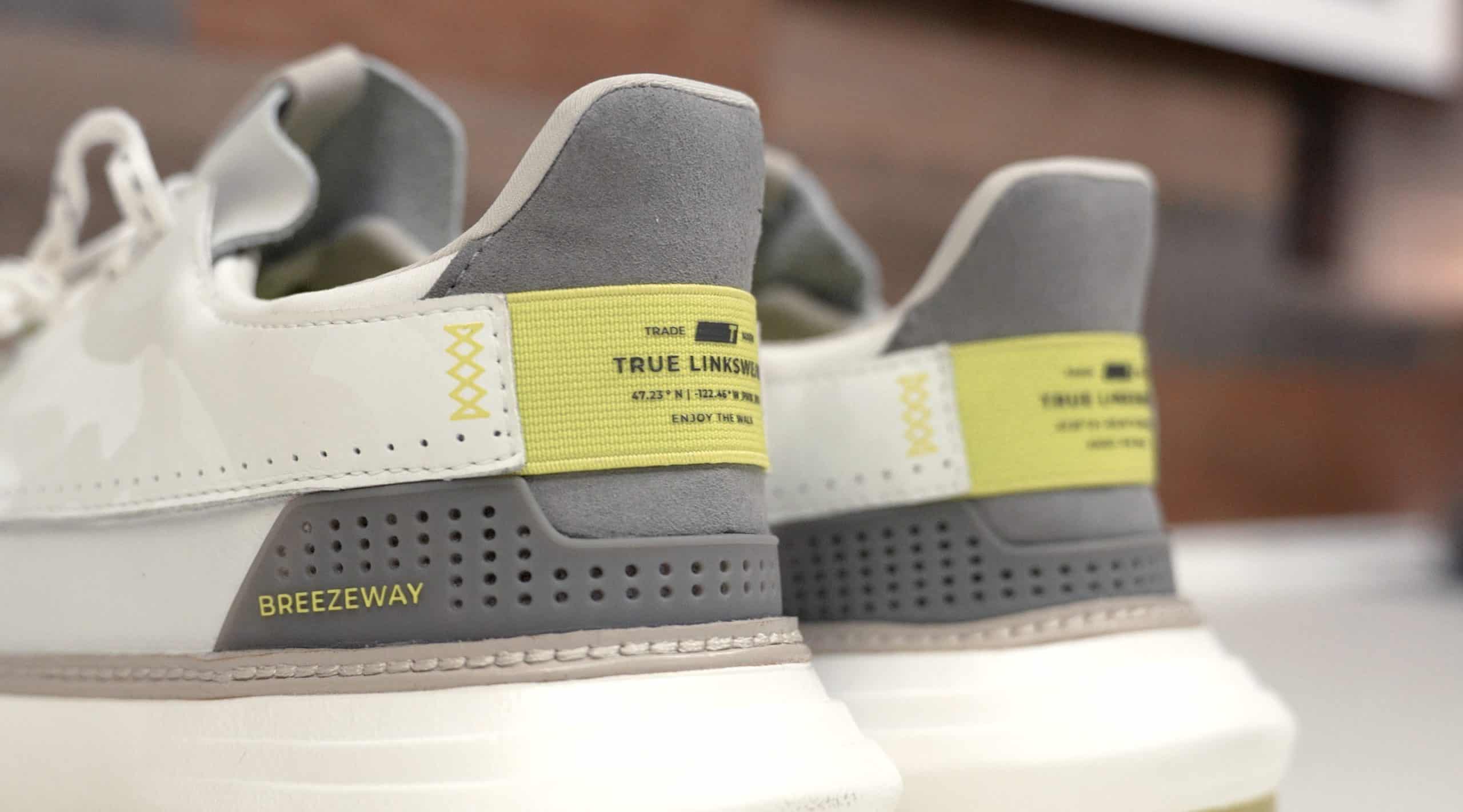 Gray and white sneakers with yellow accents