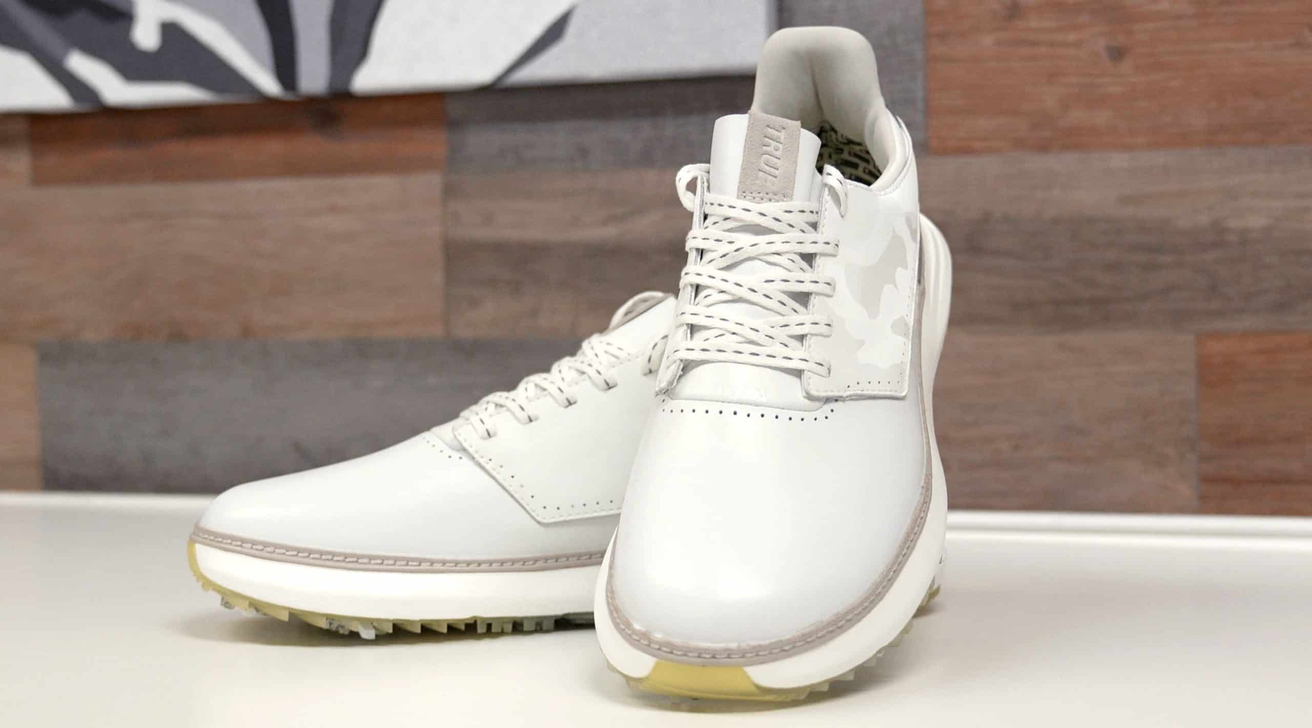 White leather golf shoes on display table