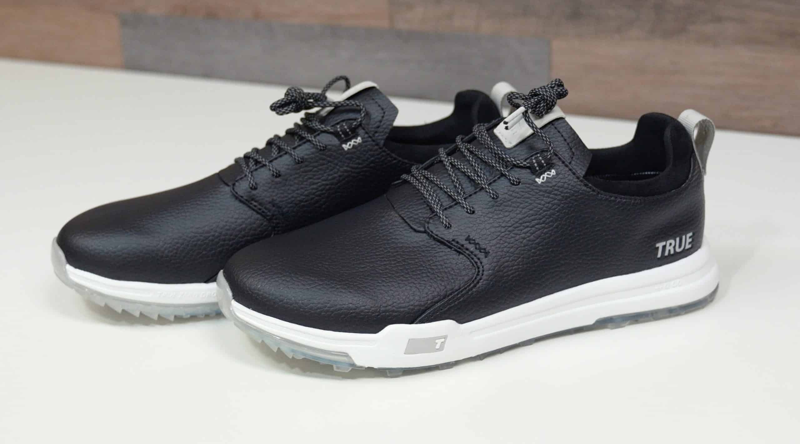 Black leather golf shoes with white soles