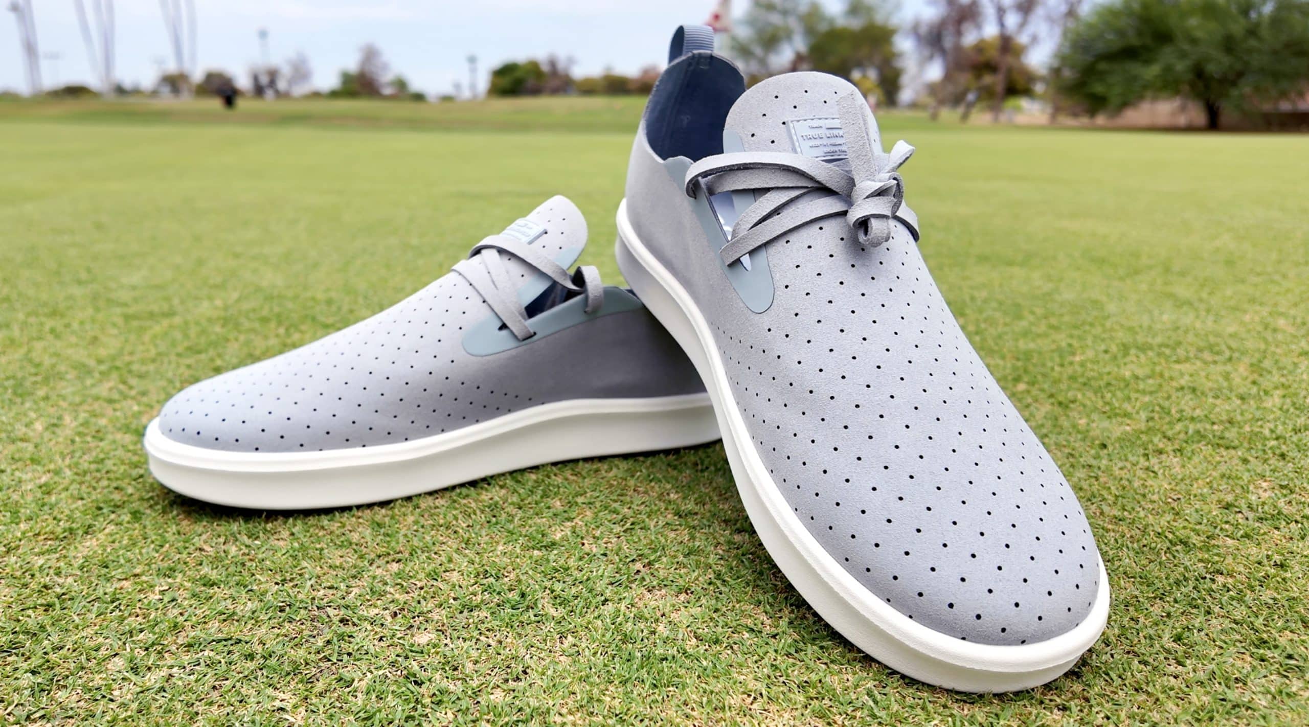 Gray perforated sneakers on green grass