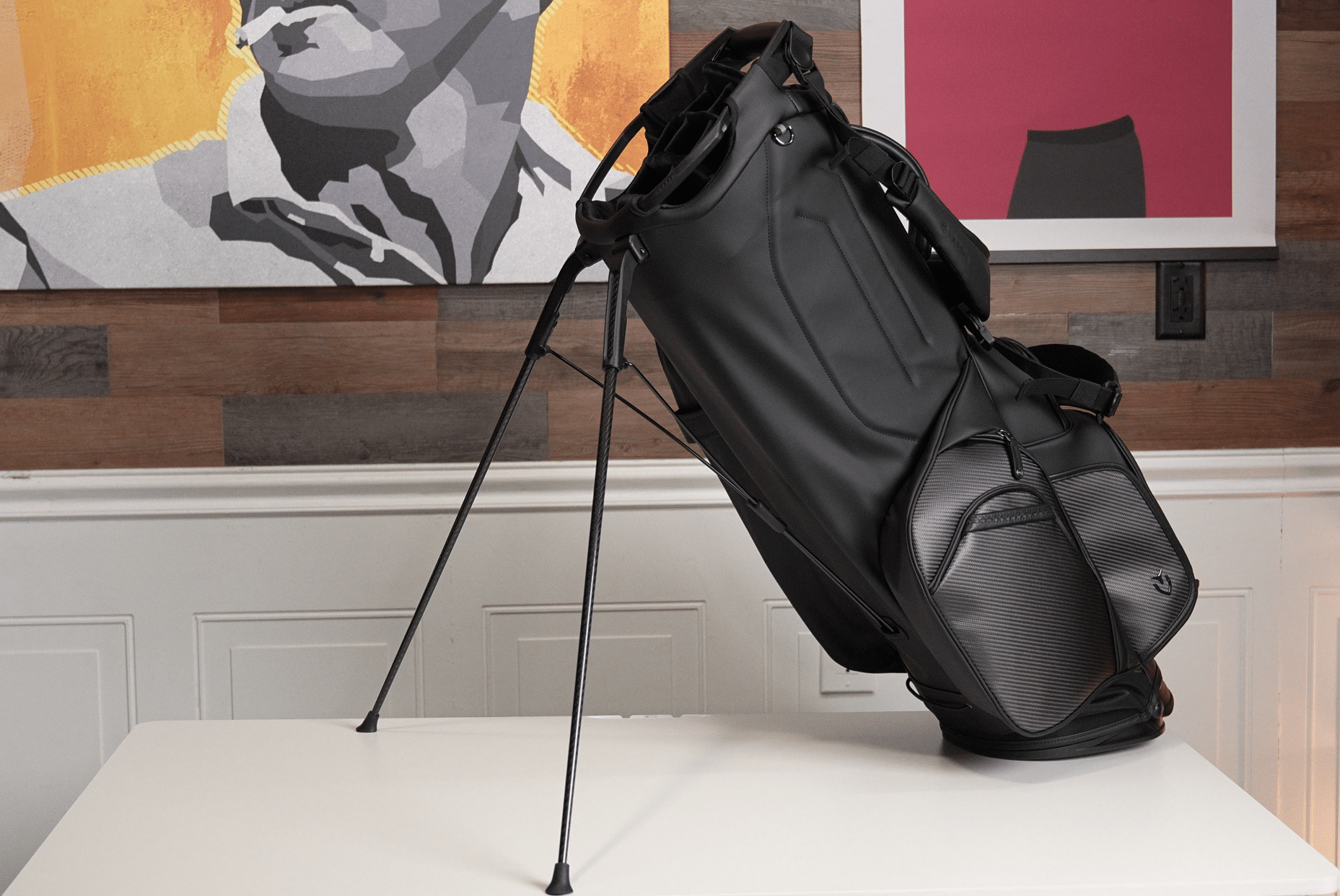 Black golf bag on stand table indoors