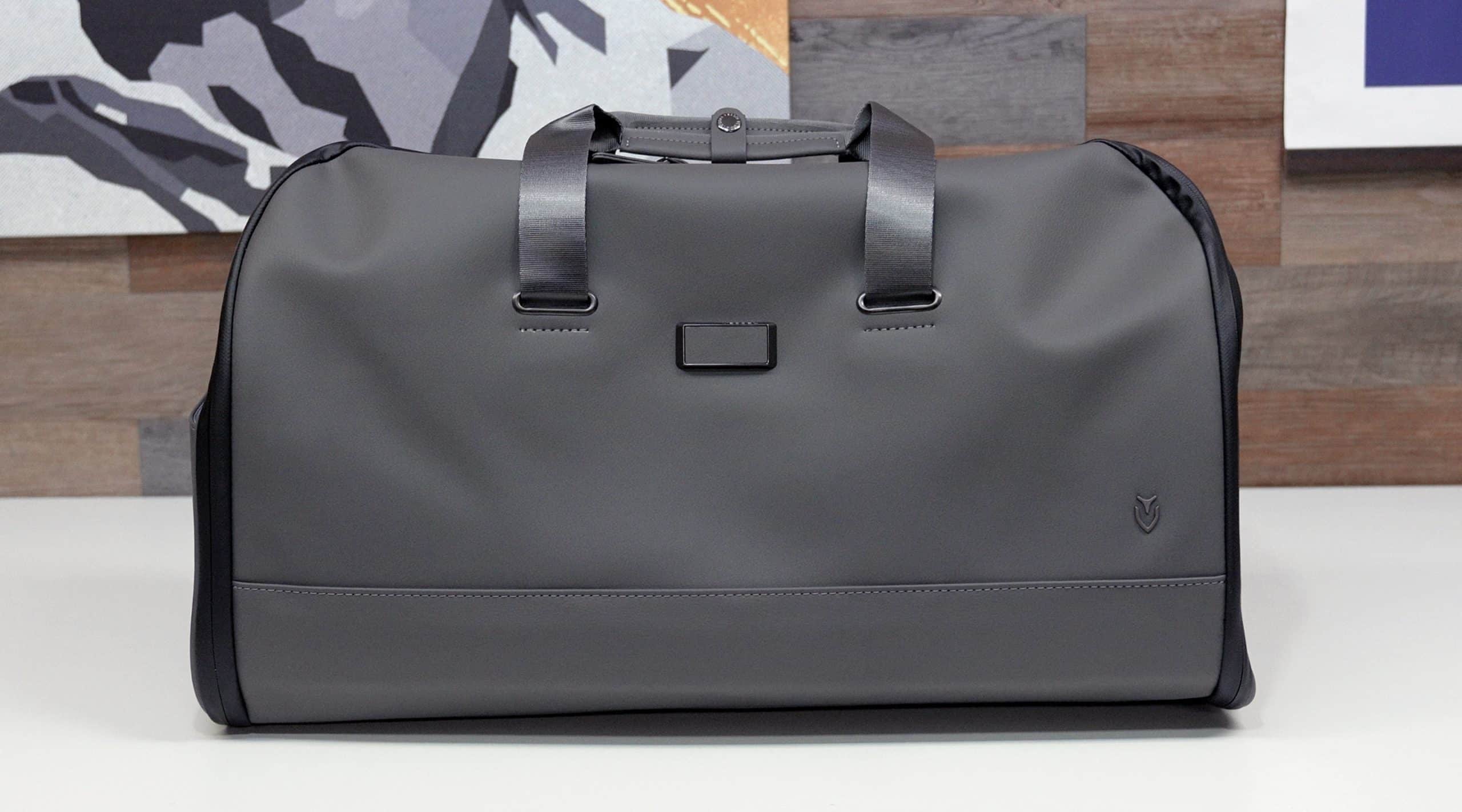 Modern gray leather duffel bag on table
