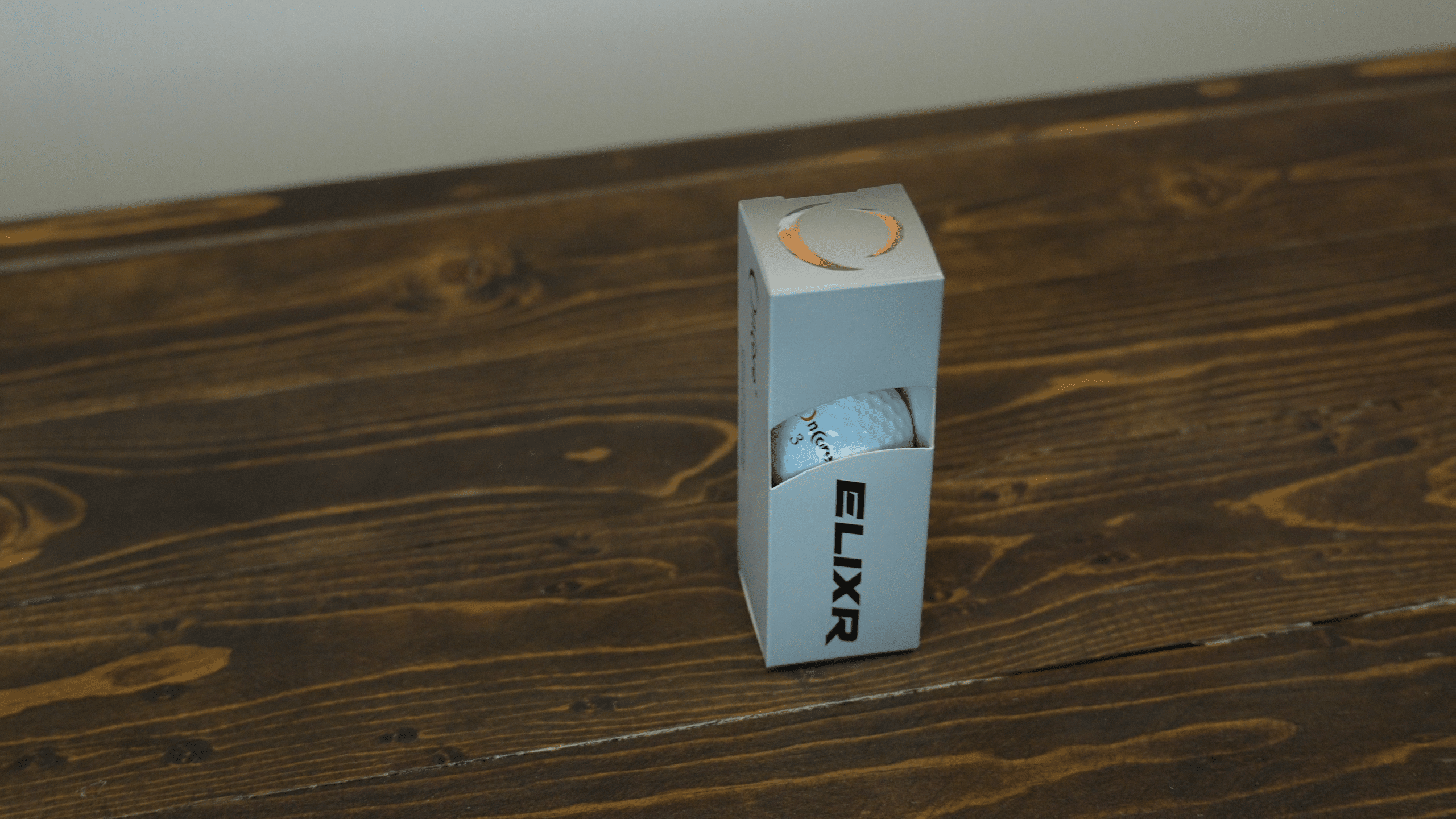 Box of ELIXR golf balls on table