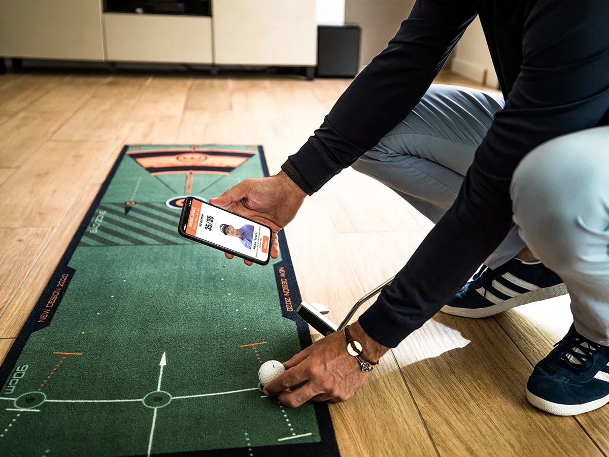 Person practicing golf putting with phone app