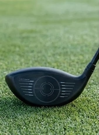 Golf driver resting on green grass