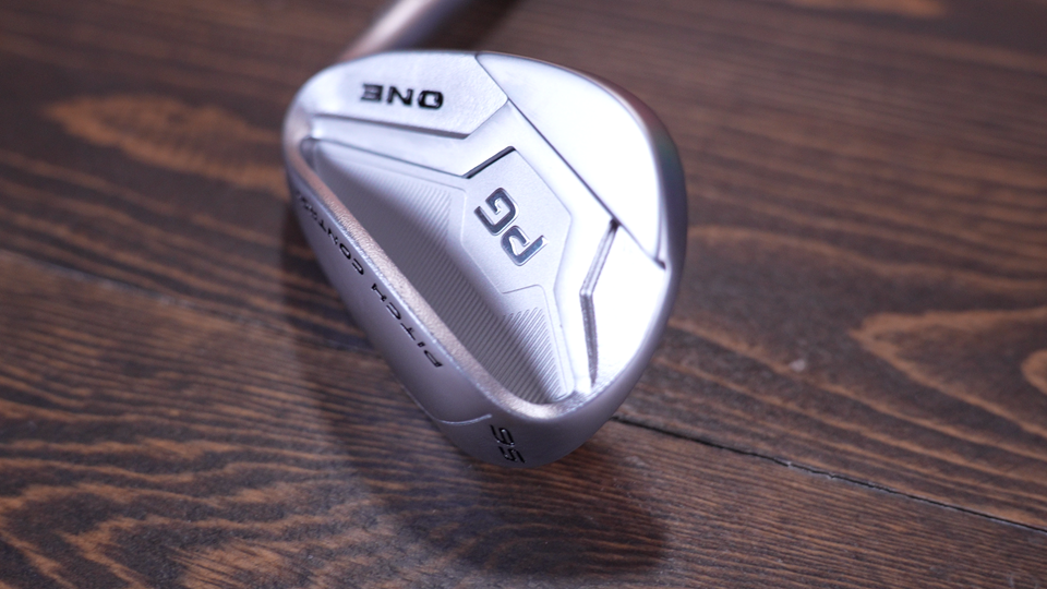 Silver golf wedge on wooden surface