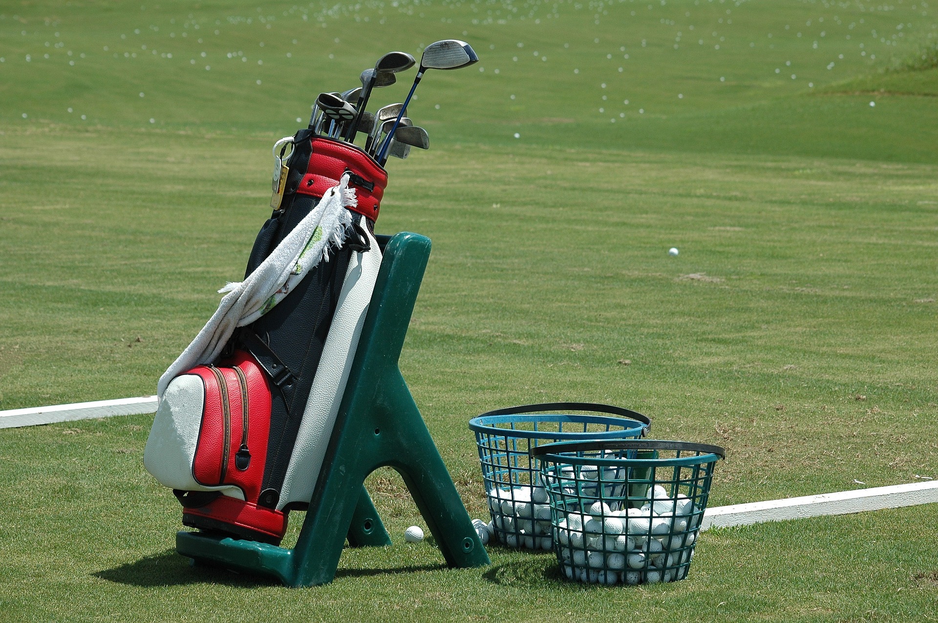 Golf clubs and balls on practice range
