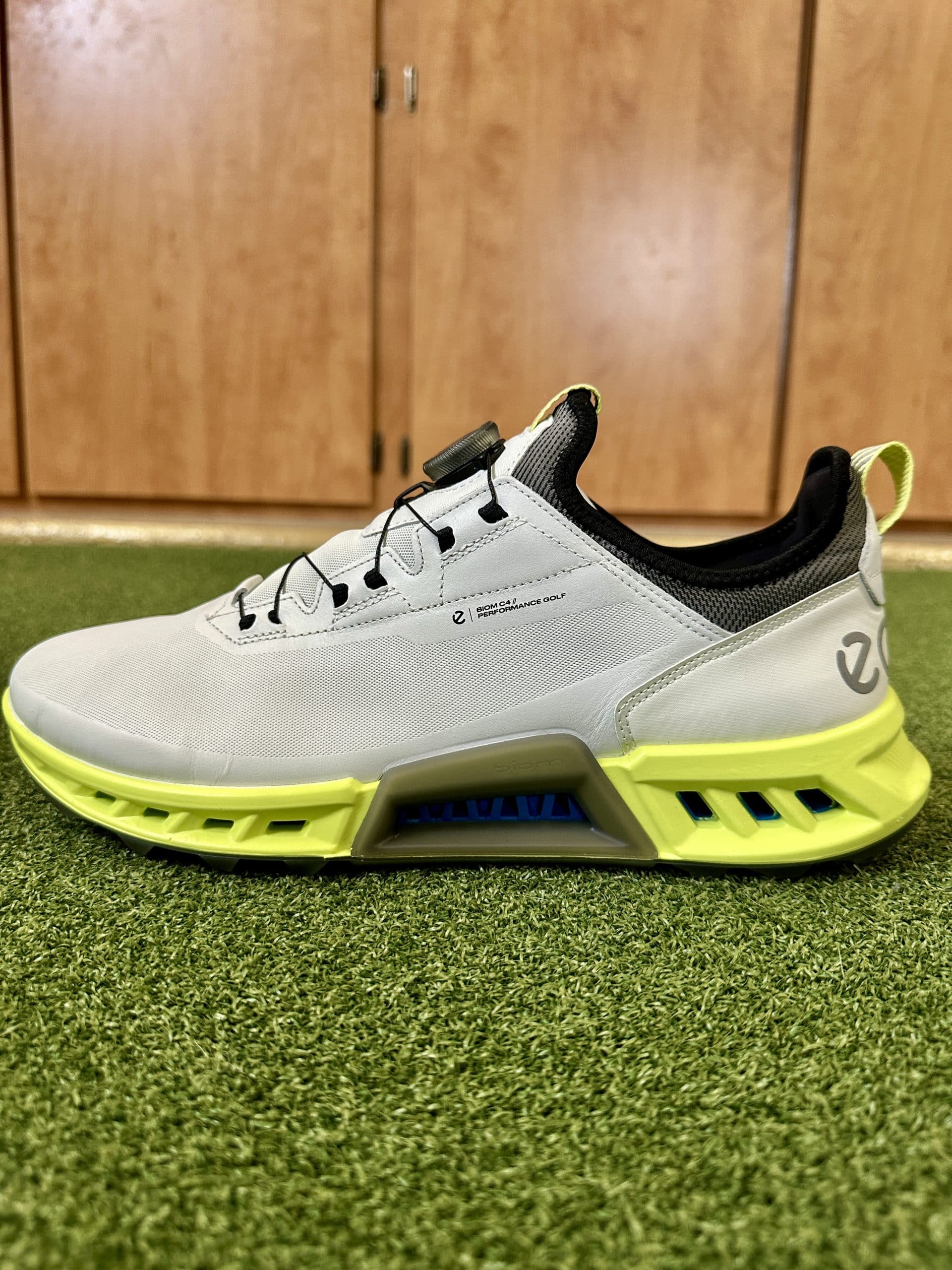 Modern gray and yellow athletic shoe on turf