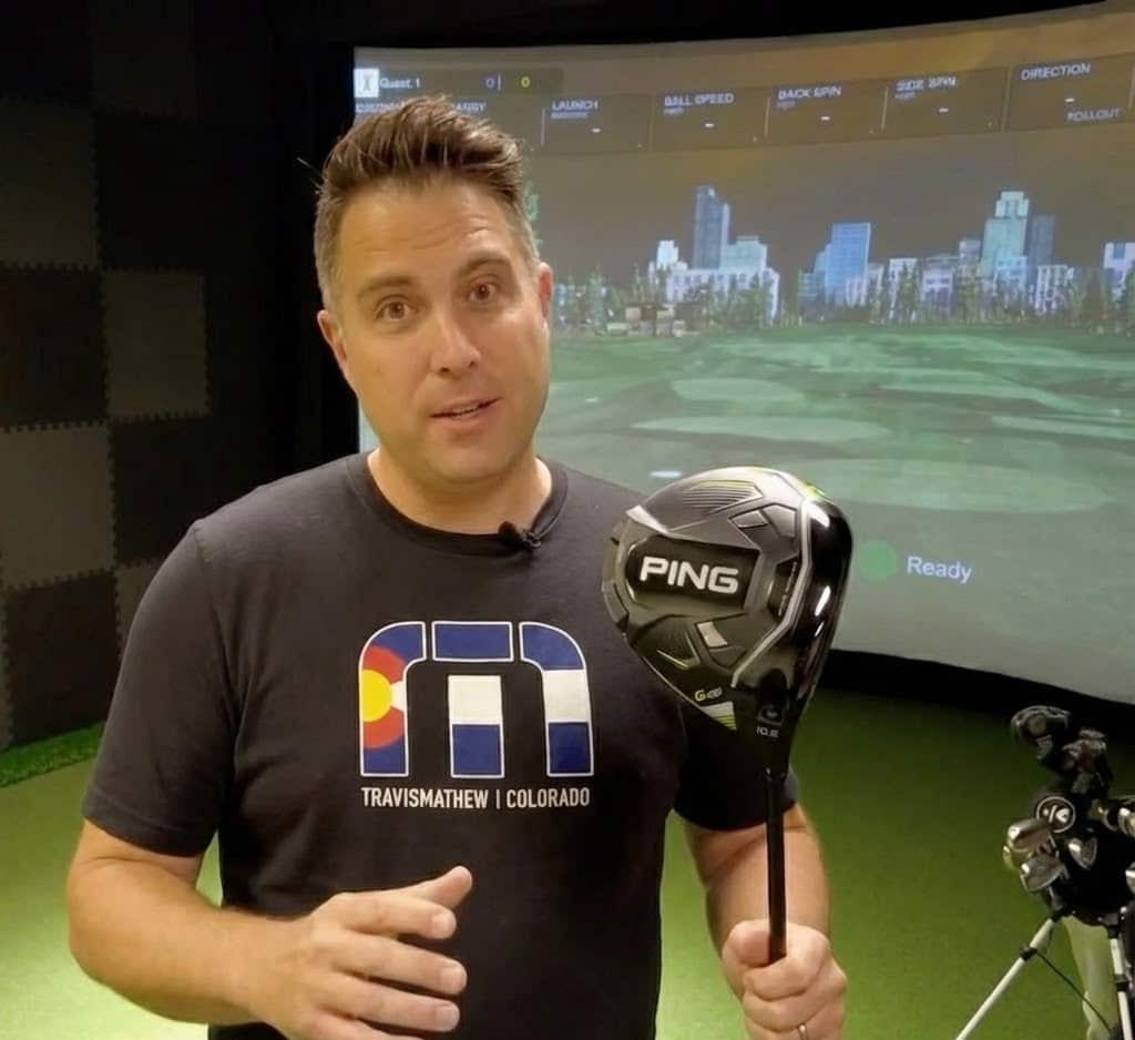 Man presenting a PING golf club indoors