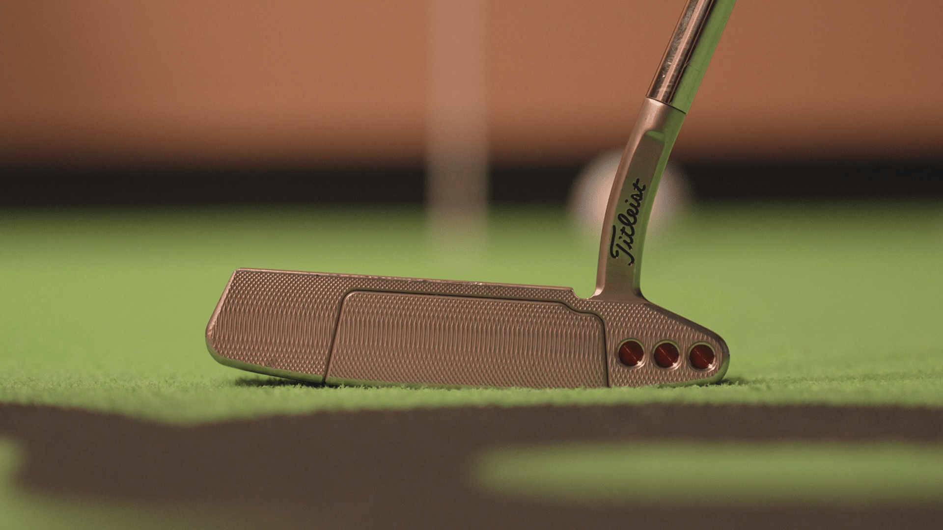Close-up of a golf putter on green turf