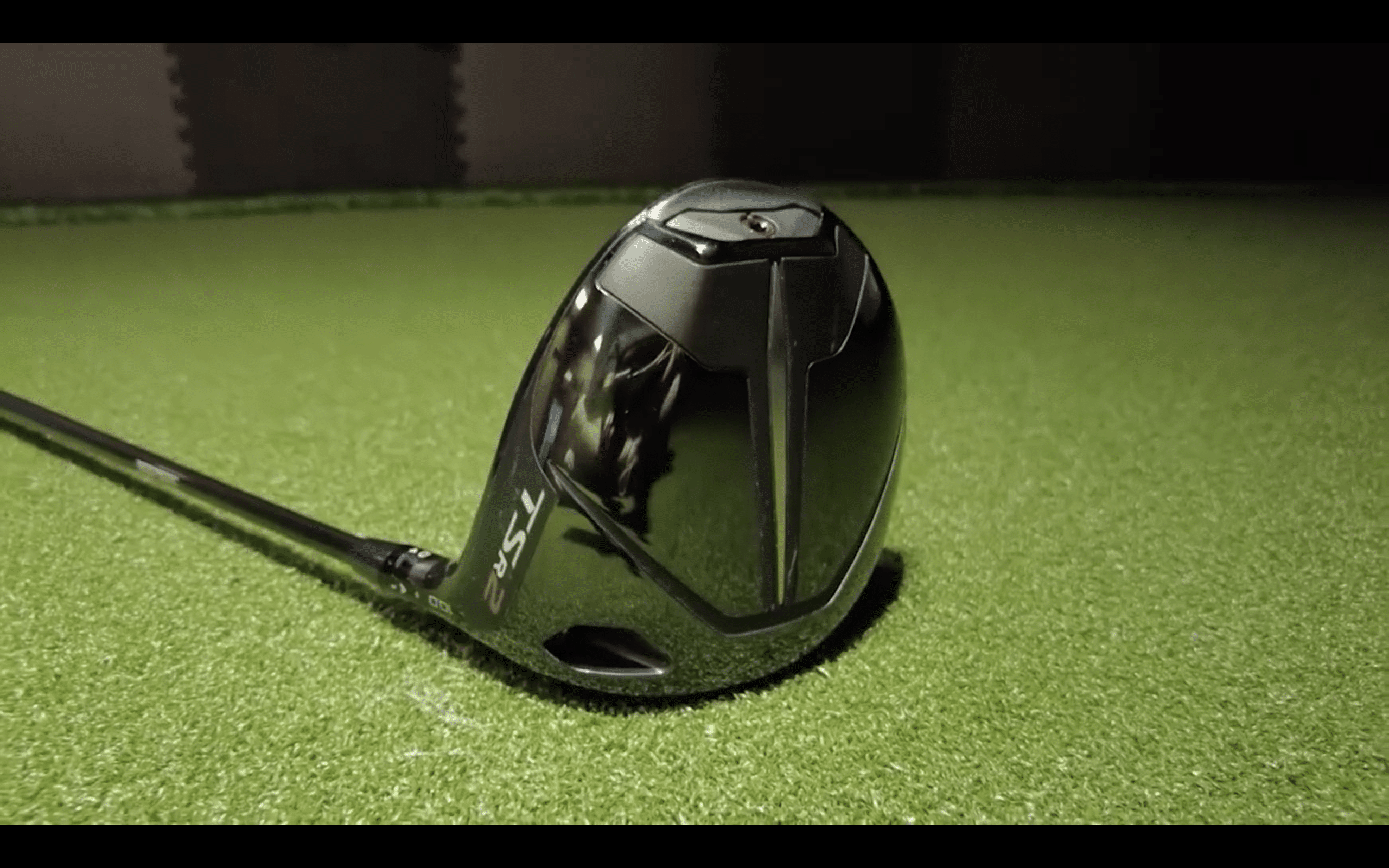 Black golf driver club on green turf