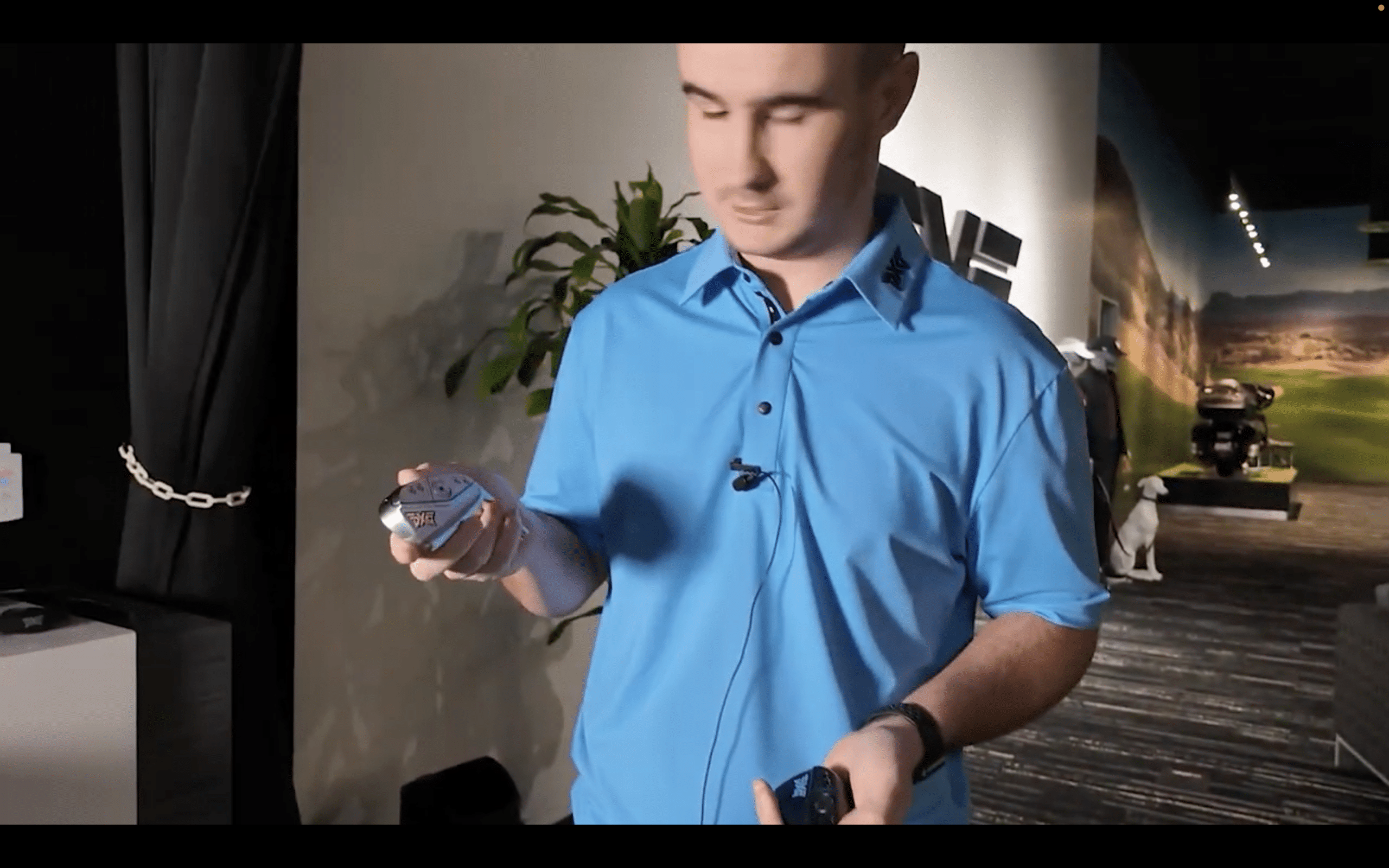 Man examining golf club head indoors