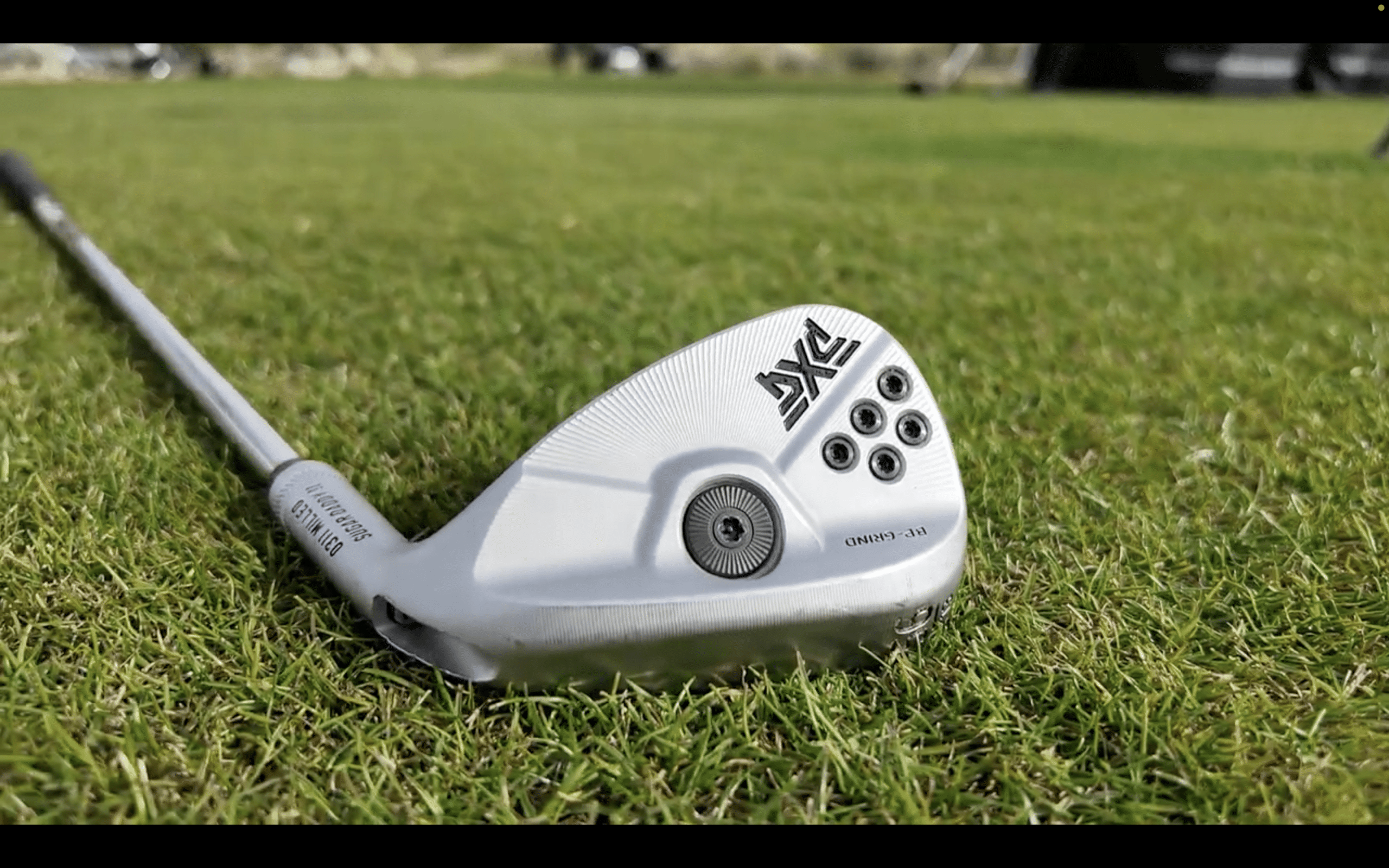 Golf wedge resting on green grass