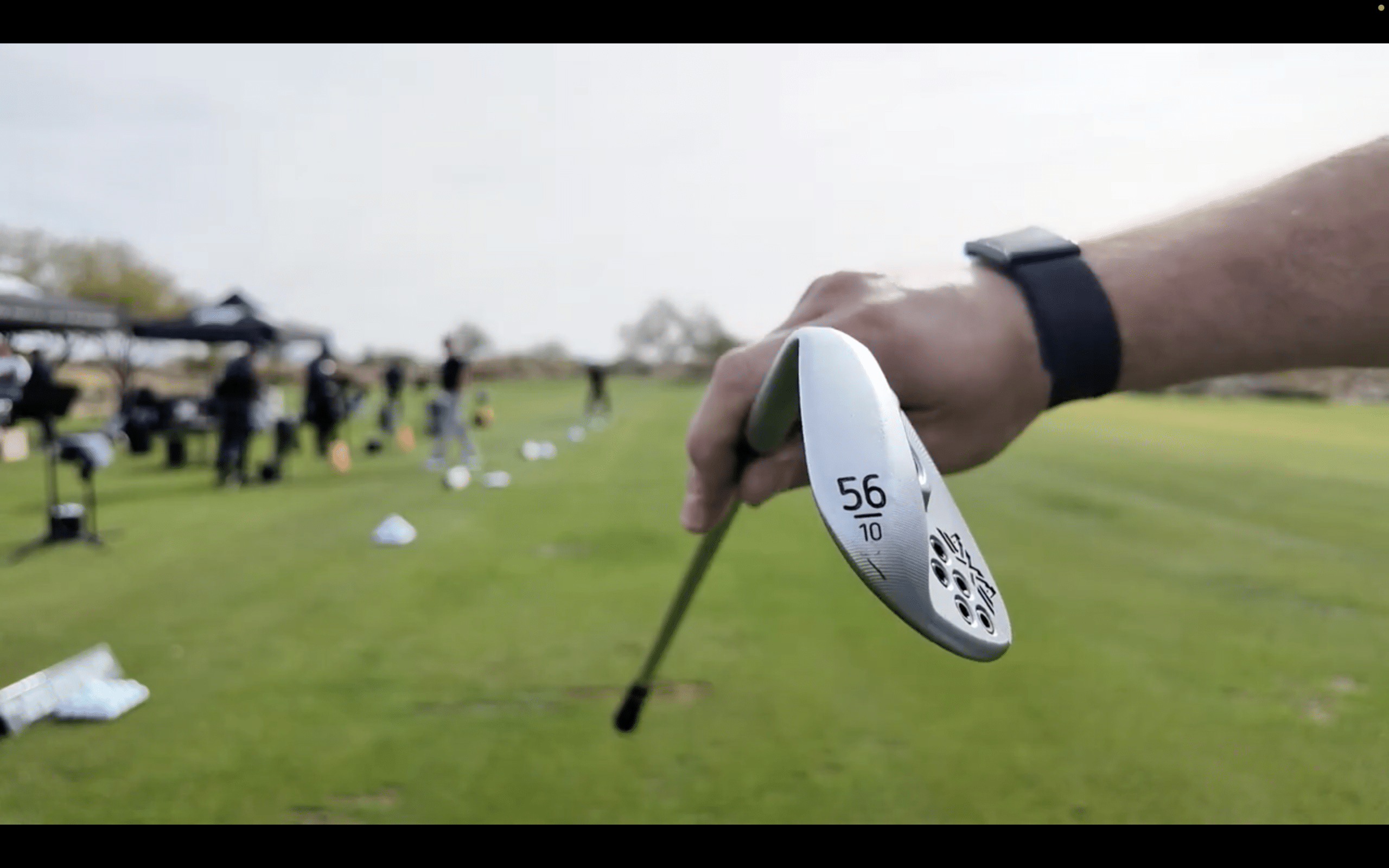 Golfer holding wedge on driving range