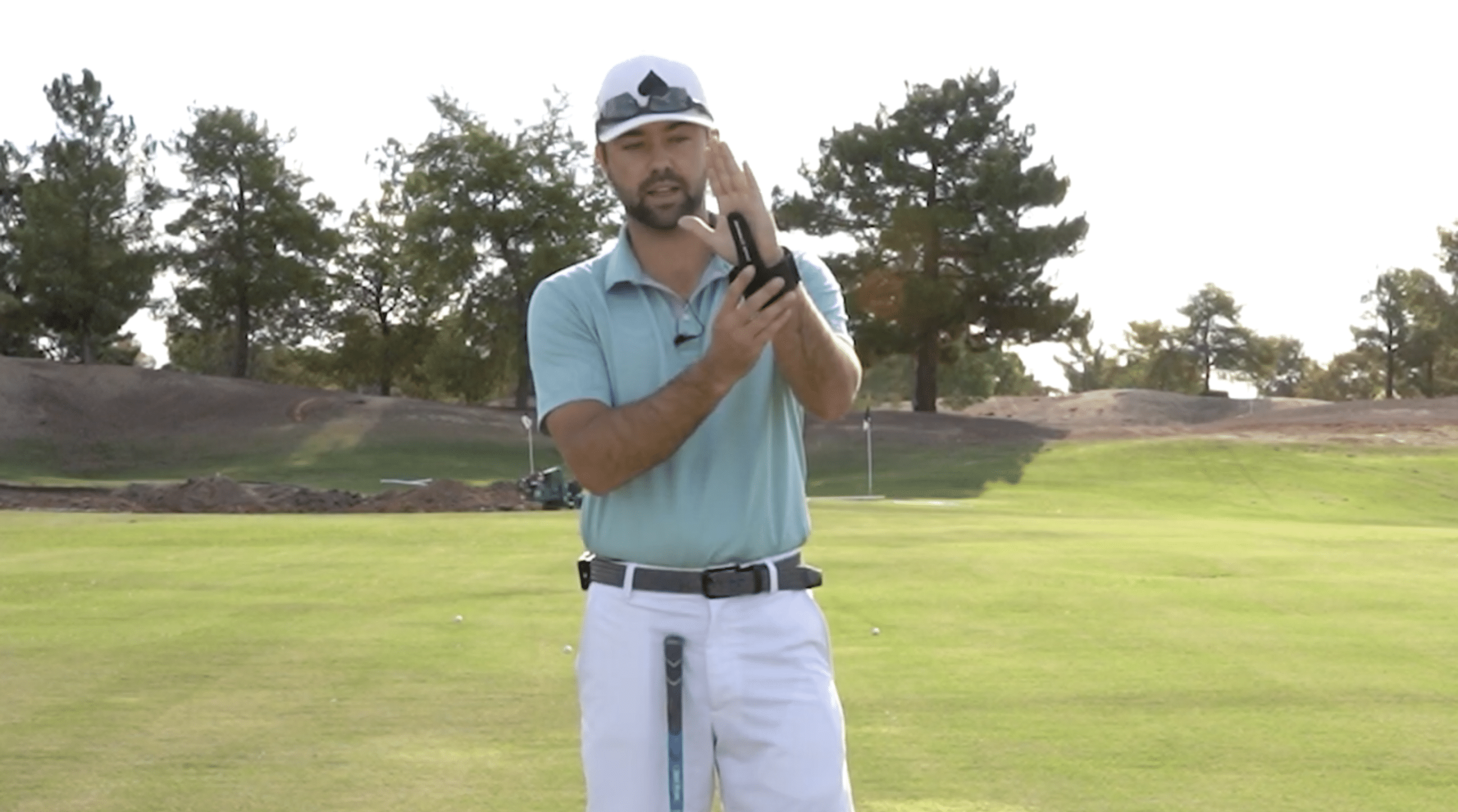 Golfer demonstrating grip on sunny golf course