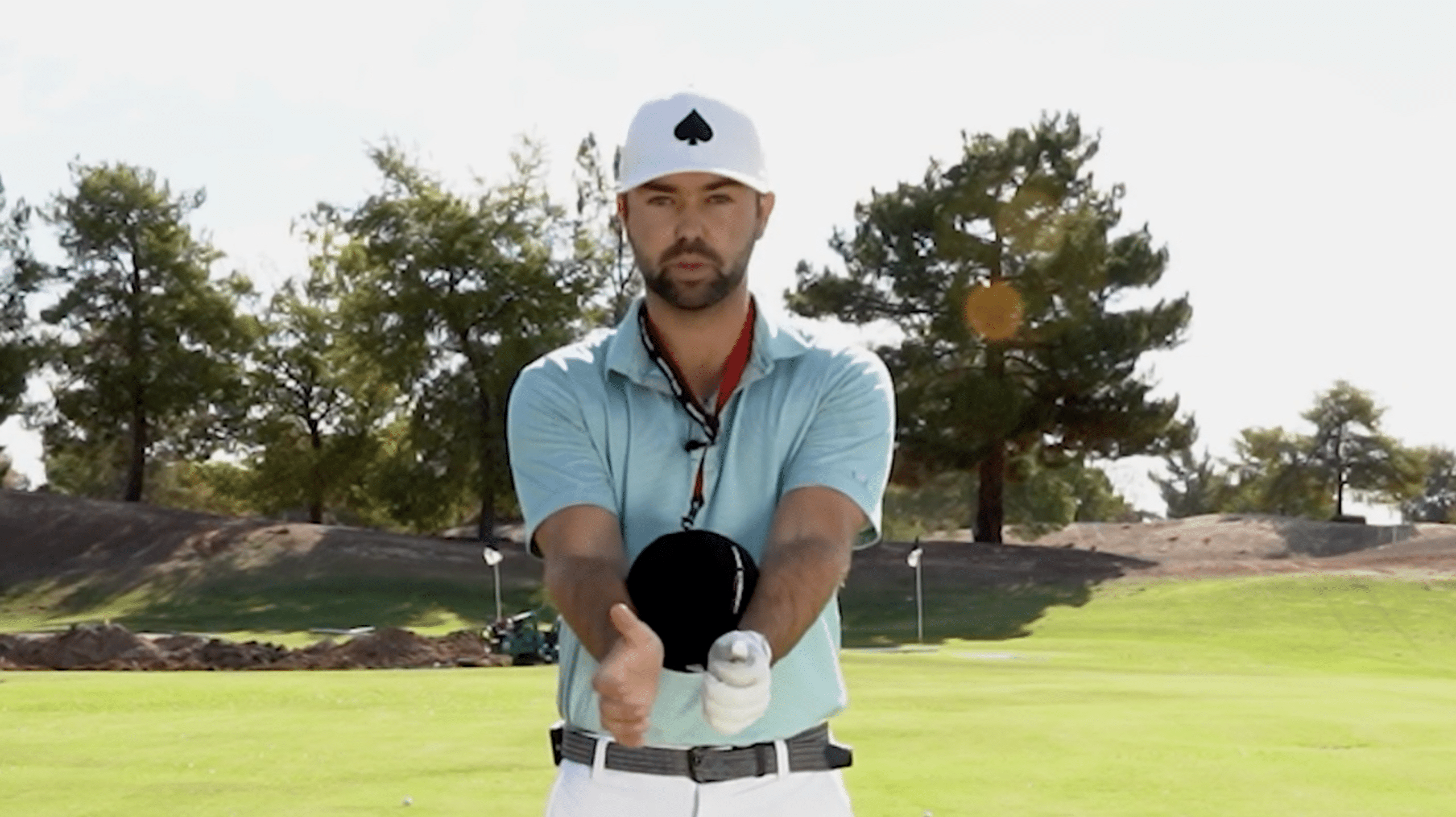 Golfer demonstrating grip on sunny golf course