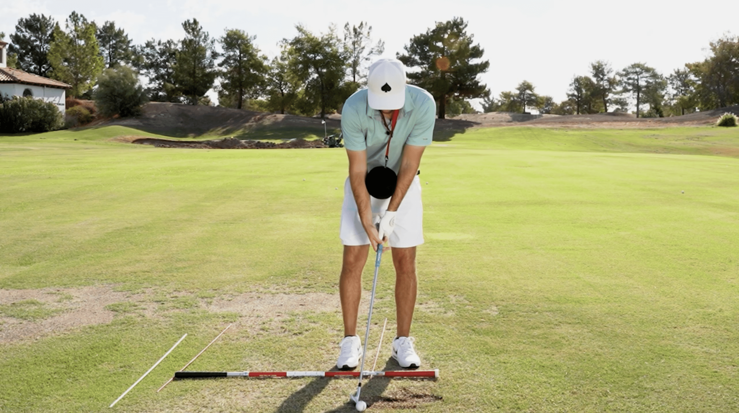 Golfer practicing stance and alignment on fairway