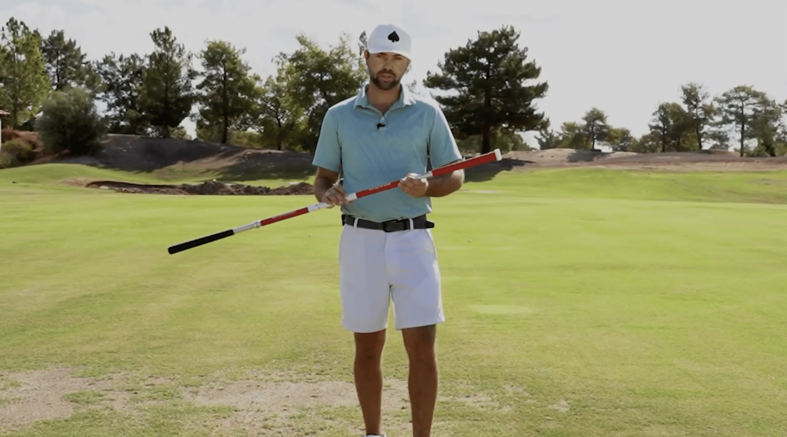 Golf instructor demonstrating on green field