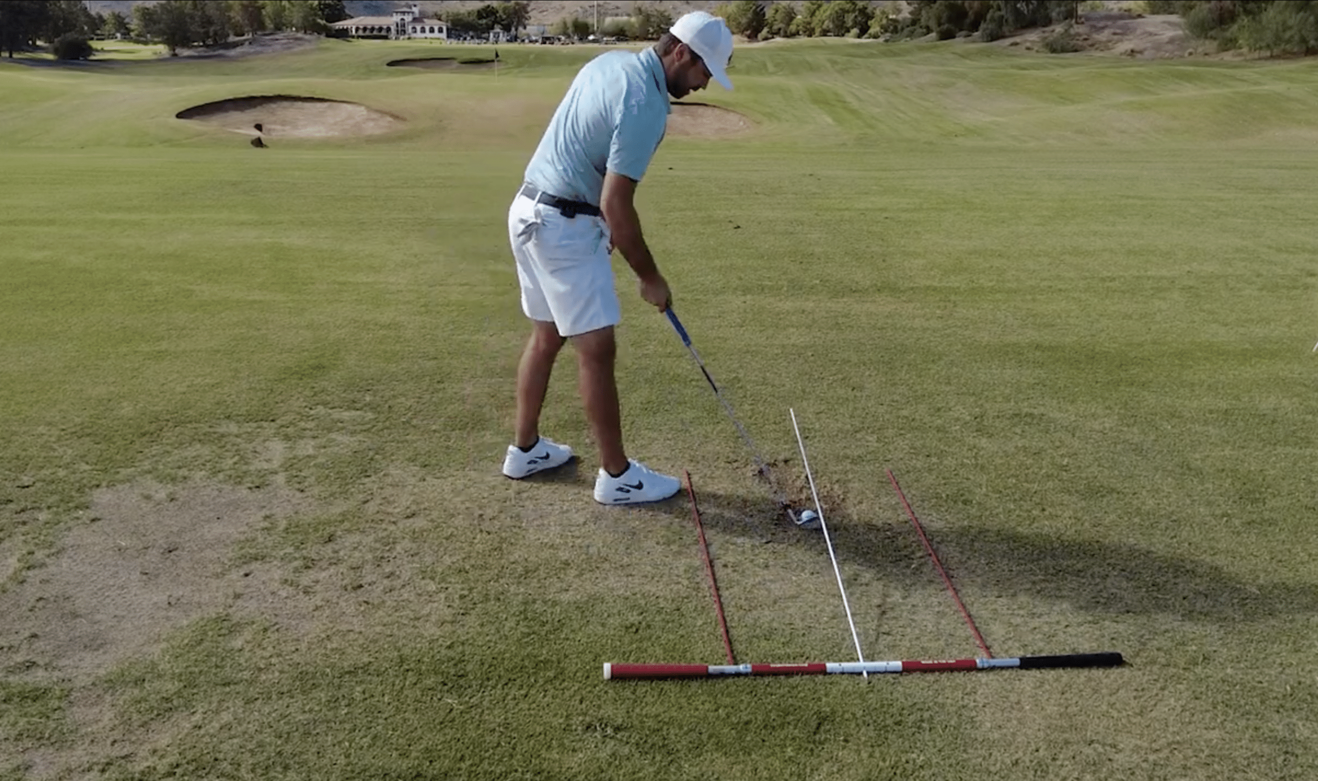 Golfer practicing swing on grassy golf course