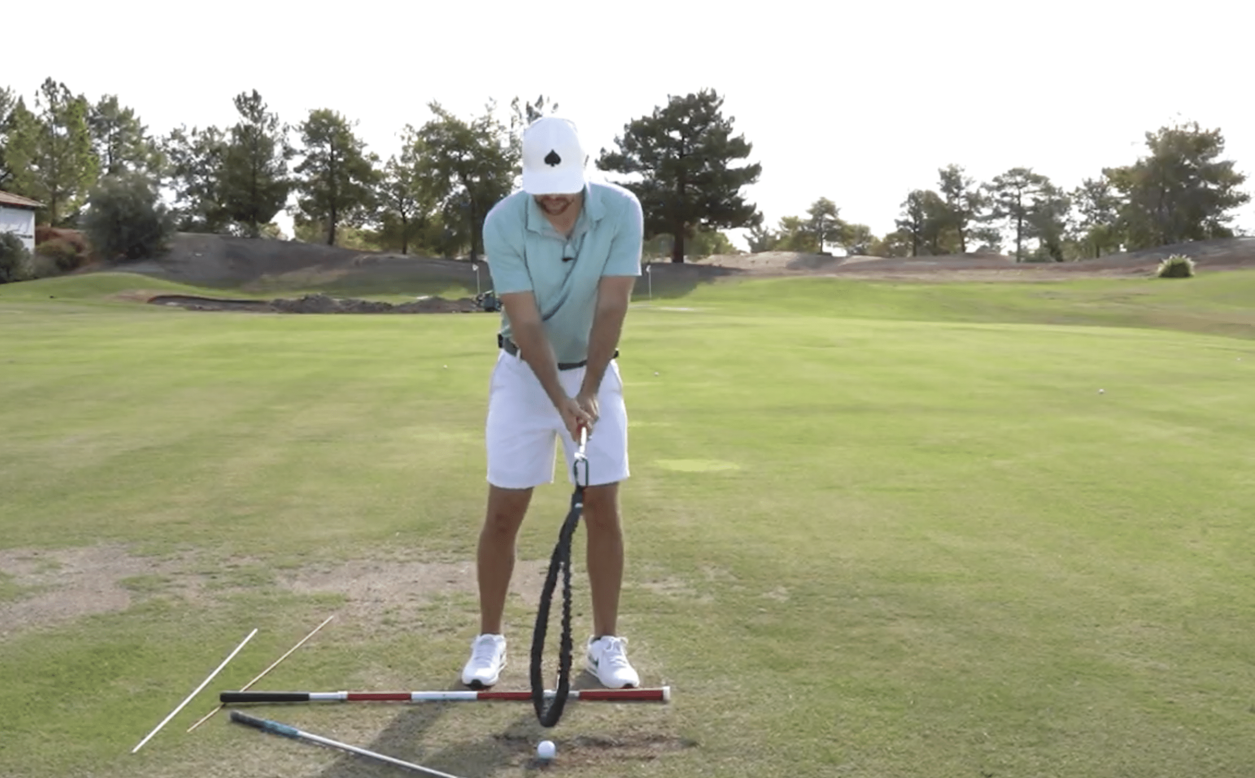 Golfer practicing swing alignment on golf course