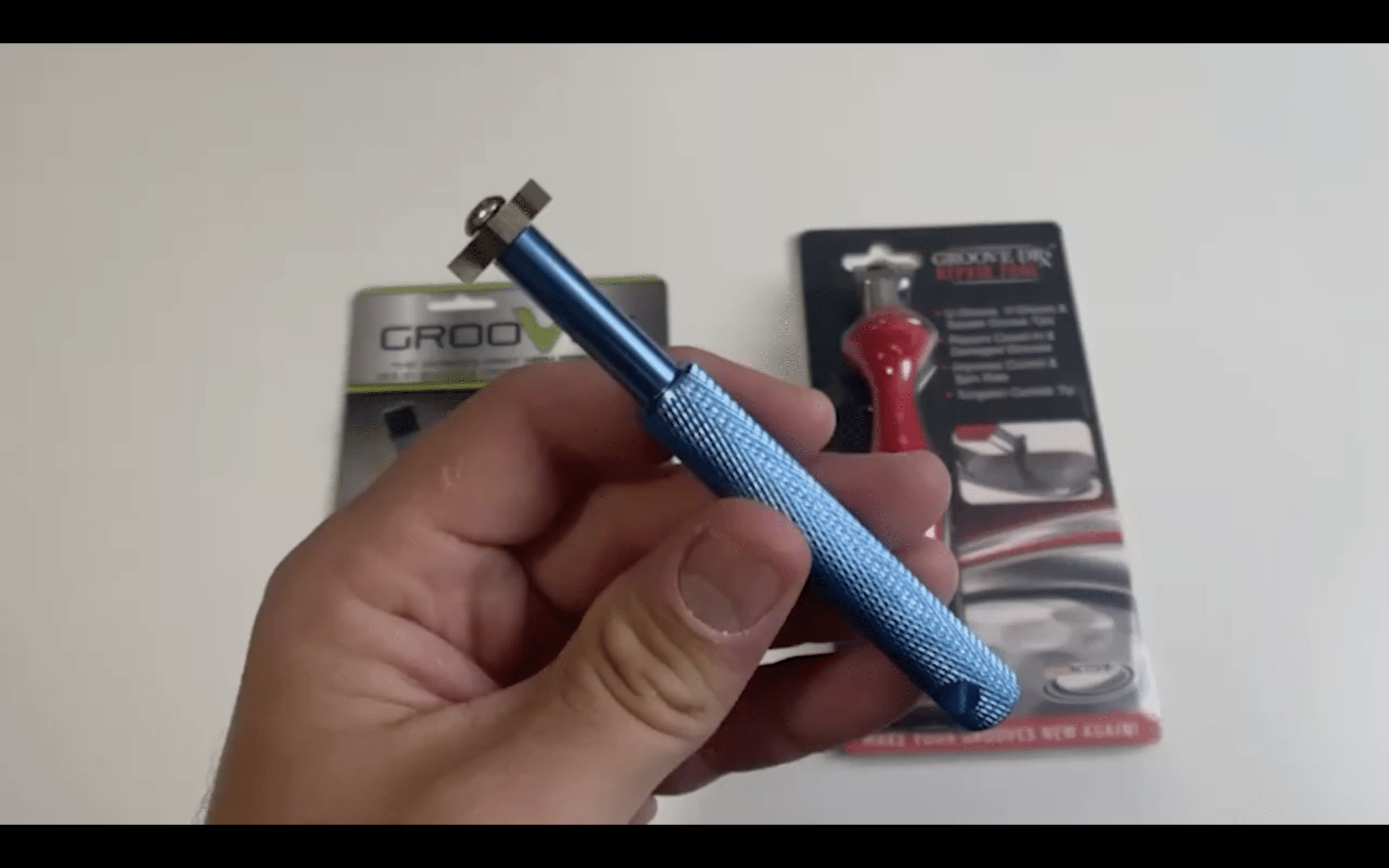 Hand holding blue glass cutting tool