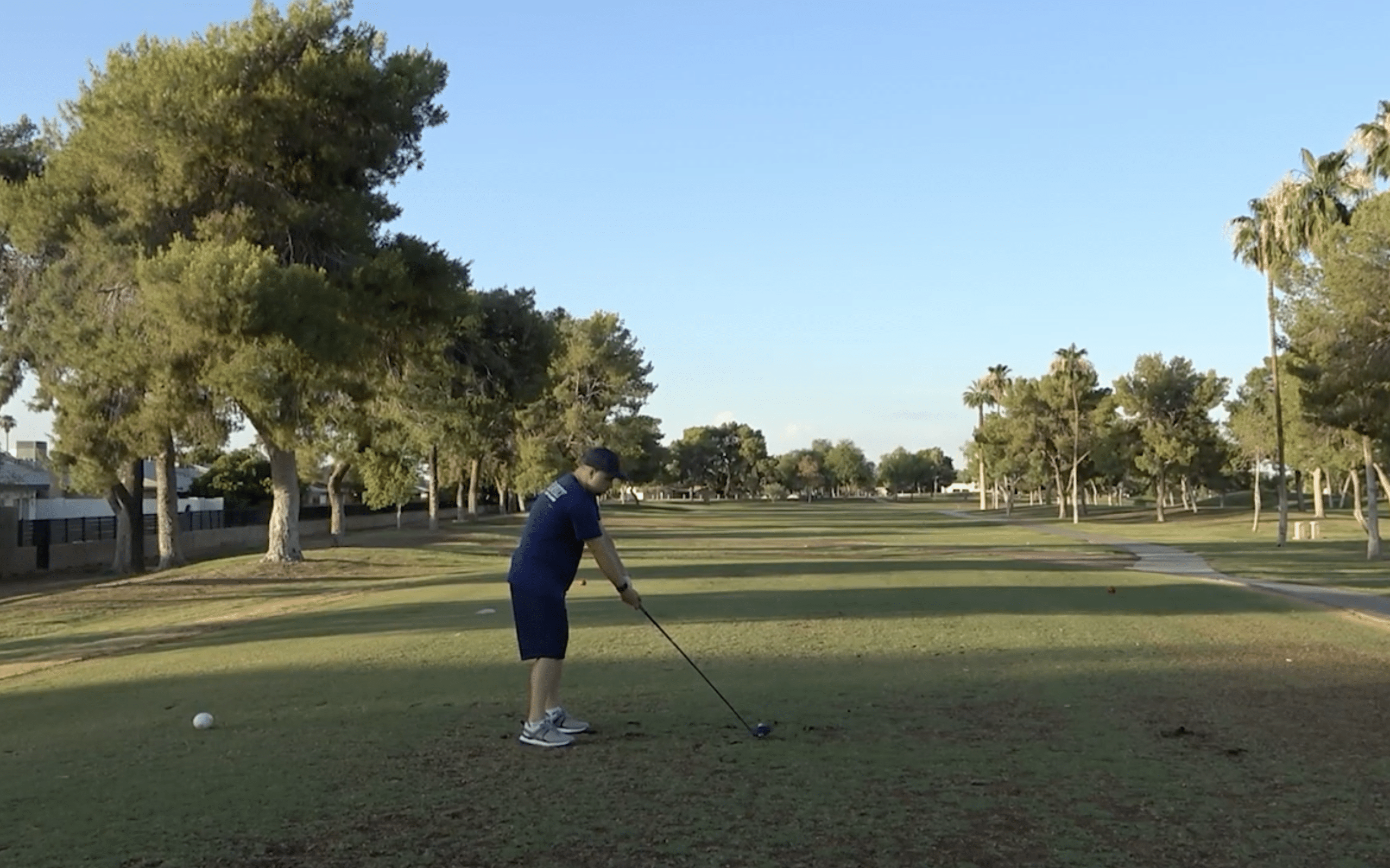 Golfer preparing to tee off on sunny course
