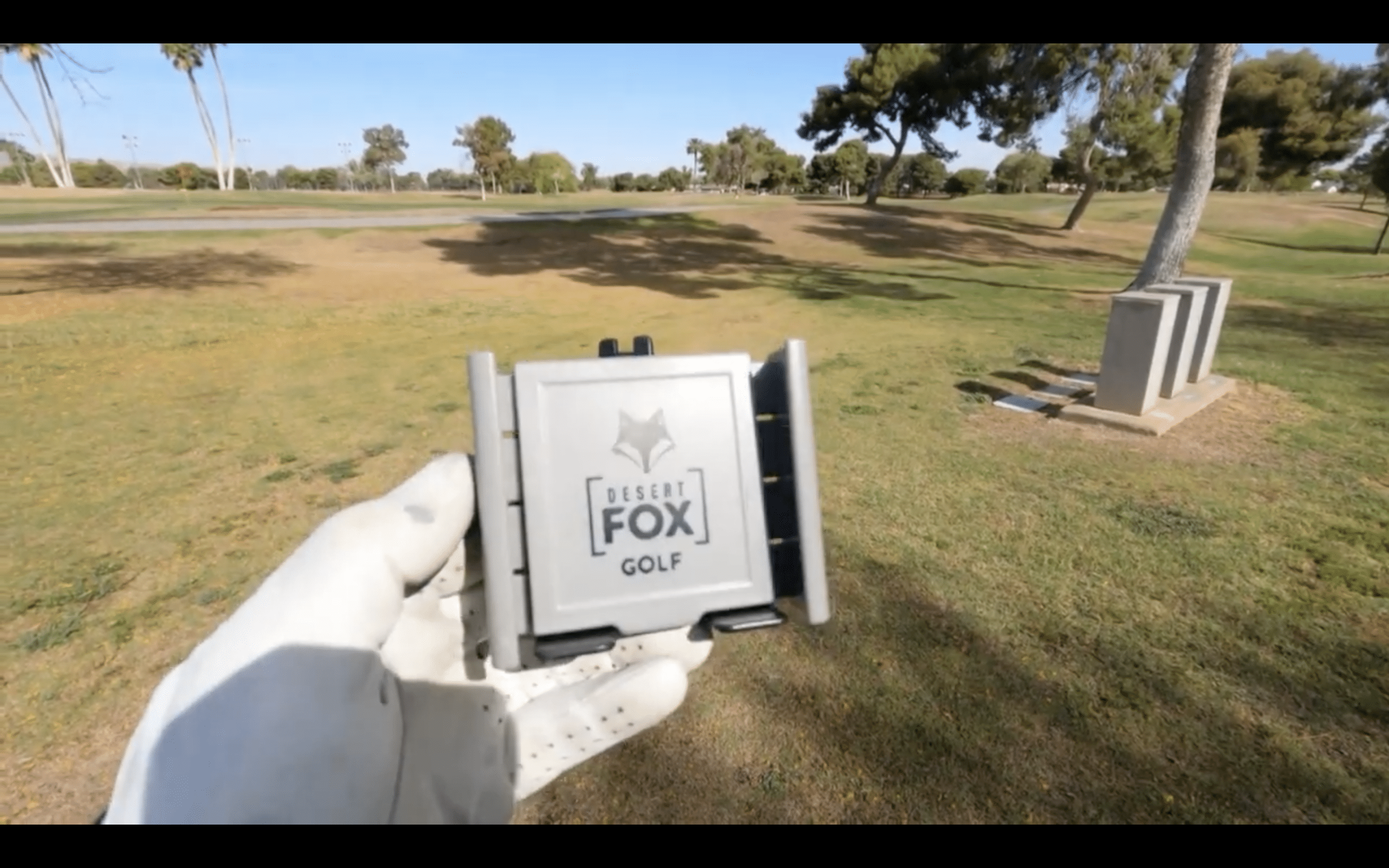 Golfer holding Desert Fox Golf phone holder