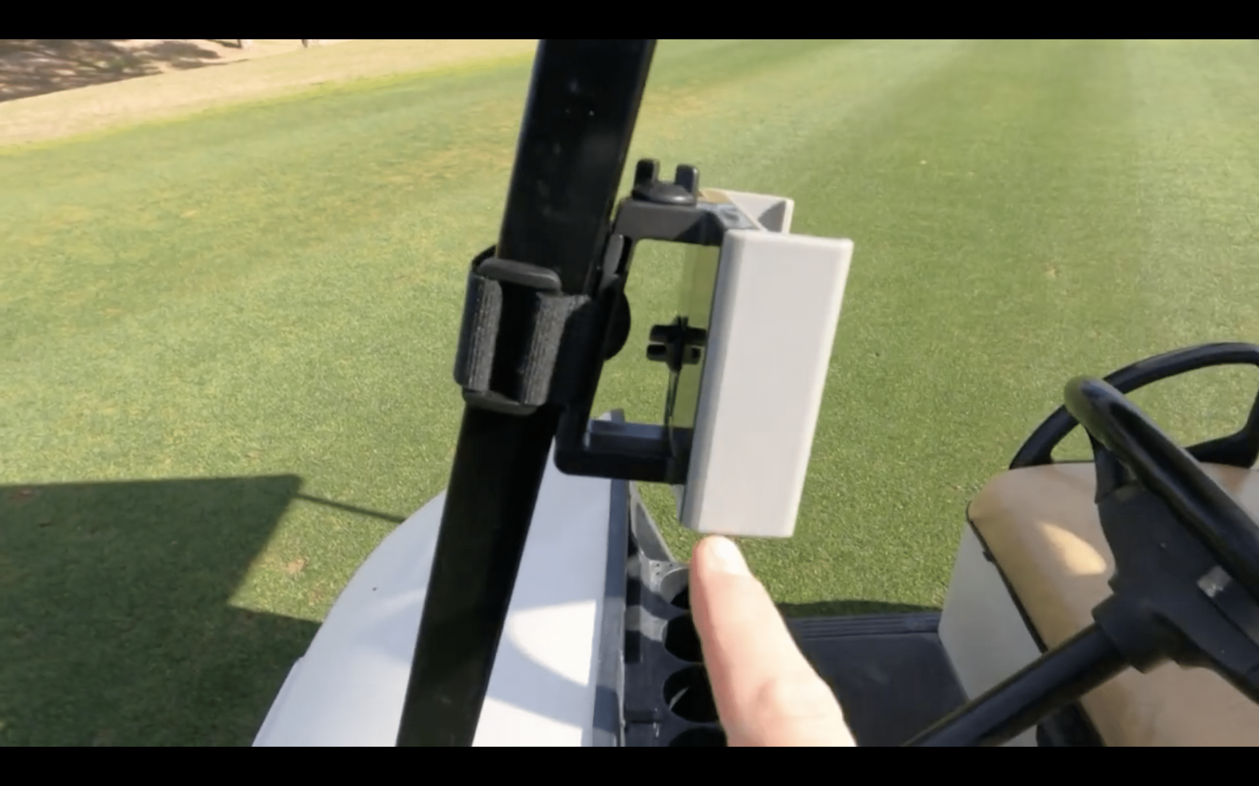 Person pointing at device on golf cart