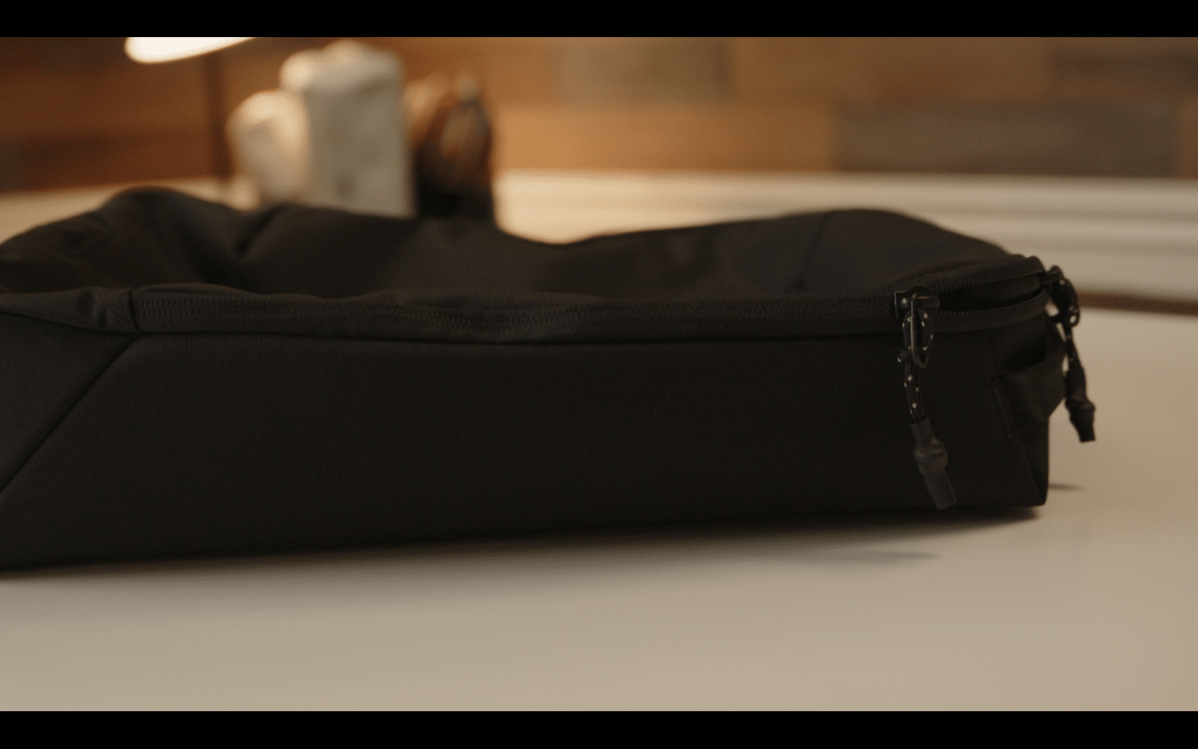 Black zippered fabric bag on table