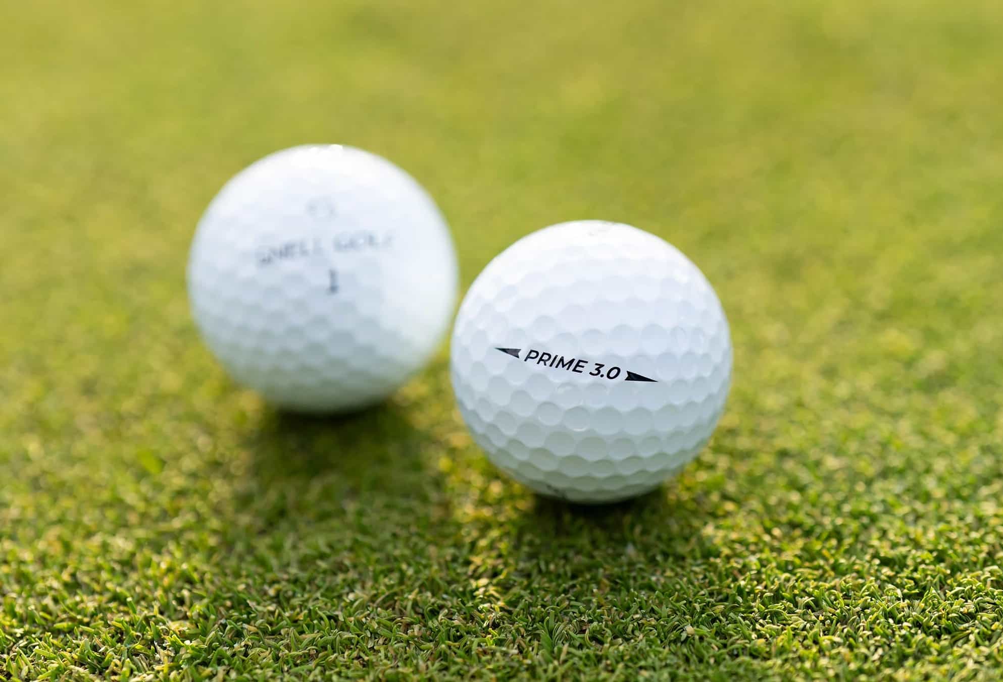 Two golf balls on green grass
