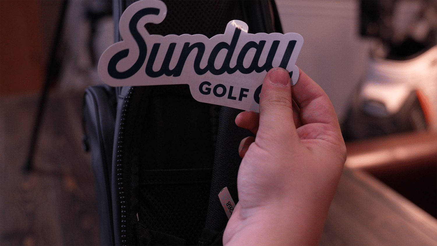 Hand holding Sunday Golf sticker