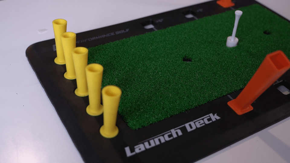 Golf training mat with yellow and orange tees