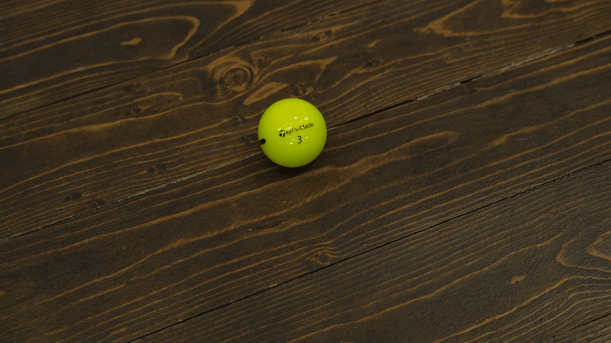 Yellow golf ball on wooden floor