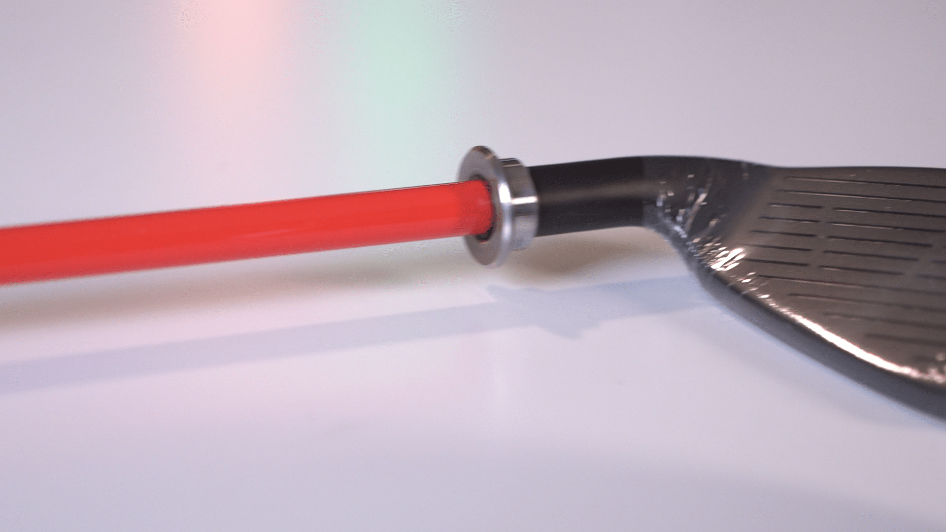 Golf club head with red shaft close-up